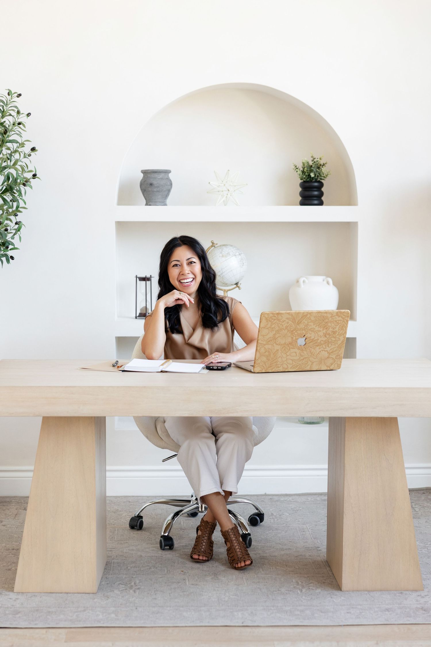 Modern minimalist workspace featuring a light wood desk and built-in shelving against white walls.