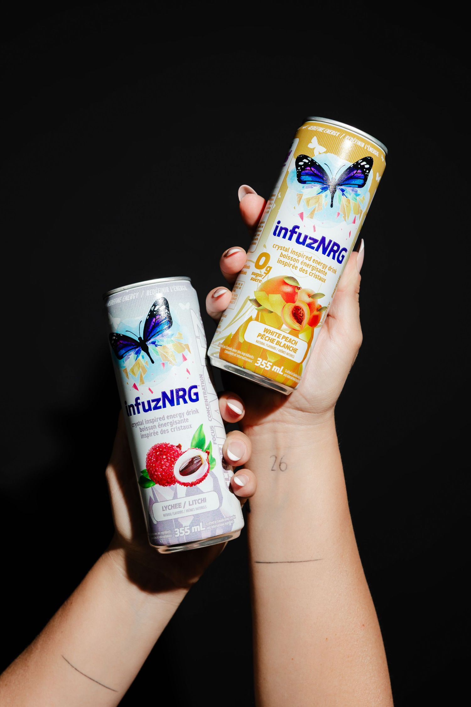 Various flavors of Milkis carbonated drinks displayed in hands against black backdrop.