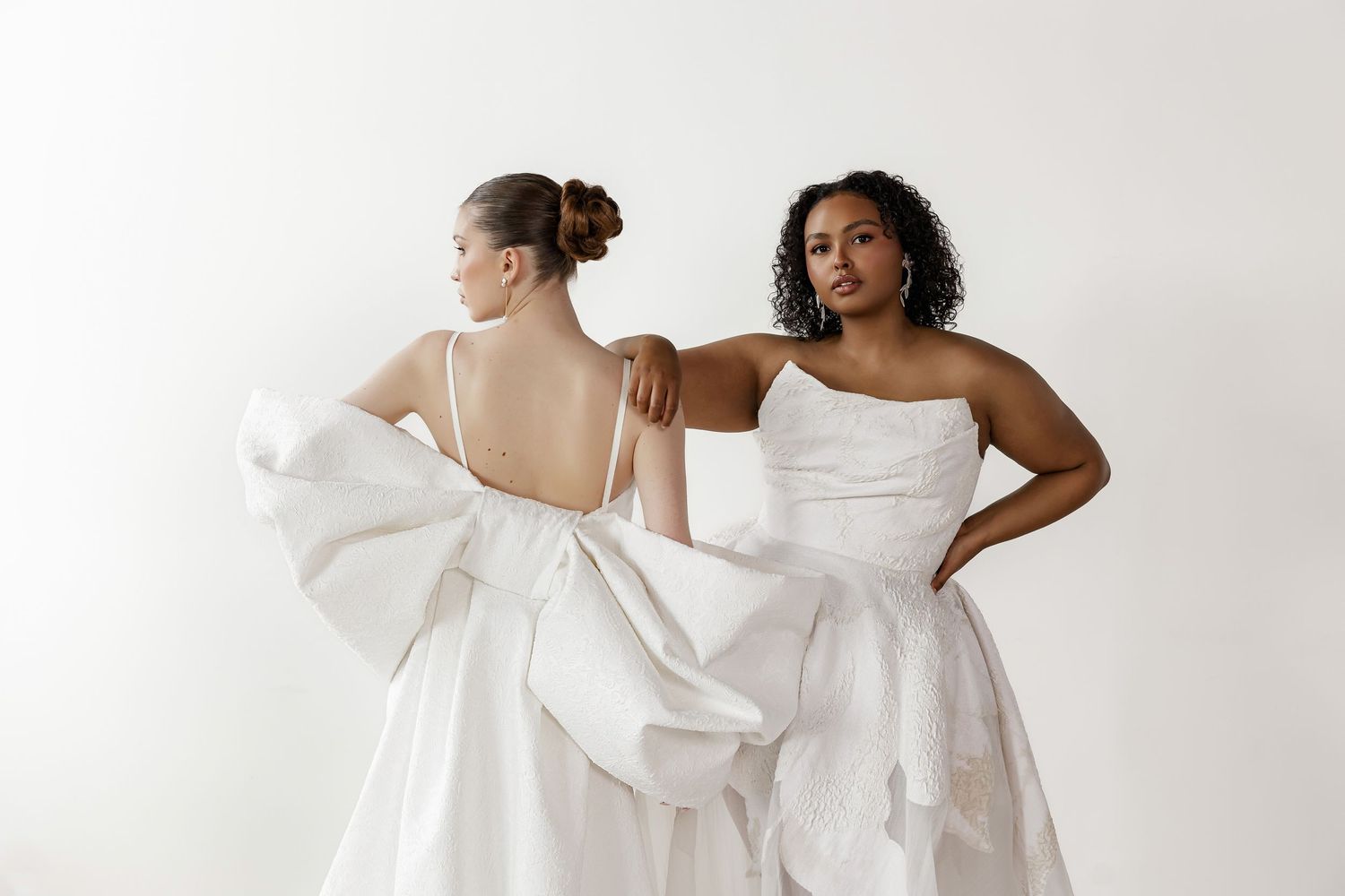 Side view of wedding gowns featuring dramatic bow details and structured silhouettes.