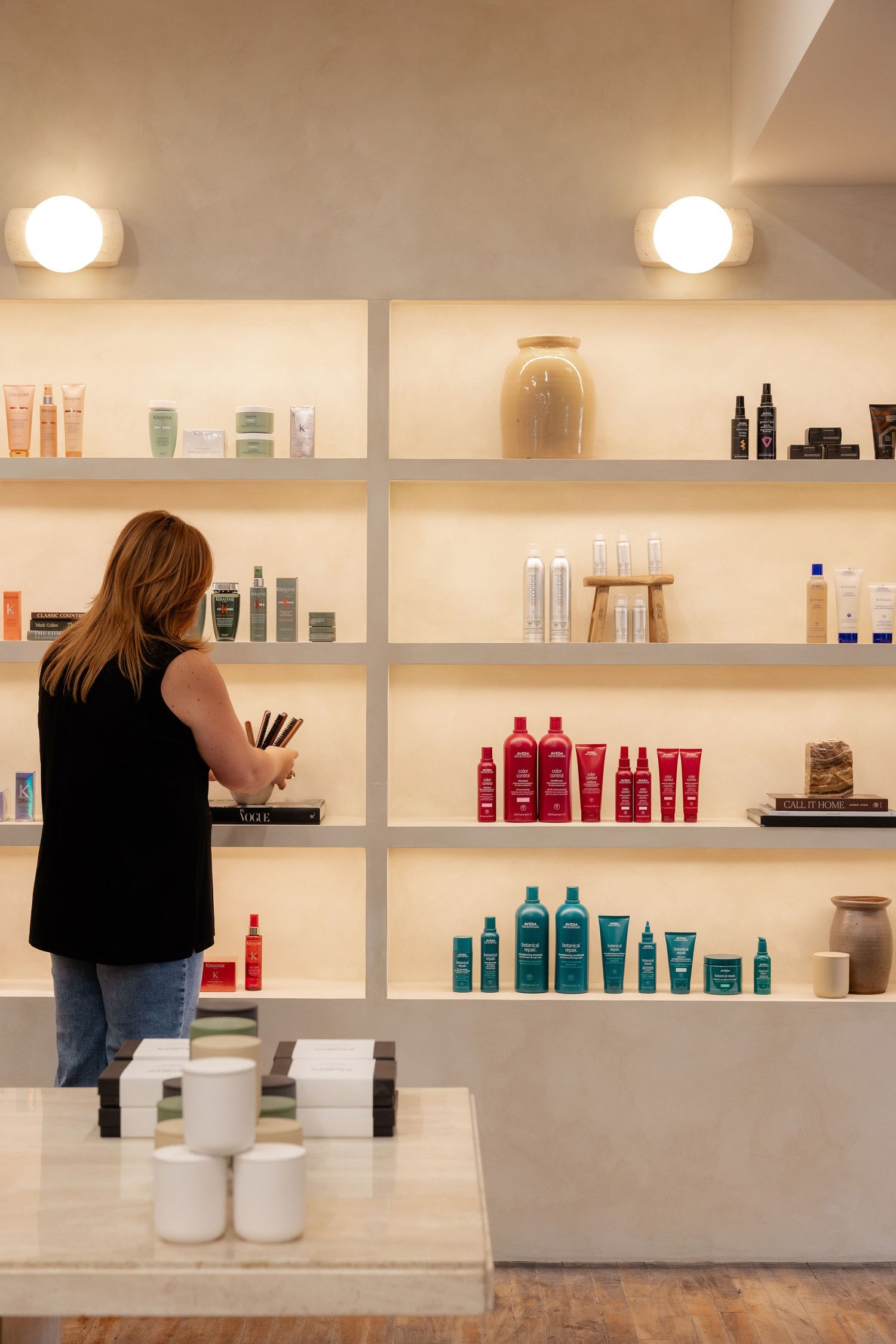 Retail display shelves with beauty and hair care products arranged neatly against white walls.