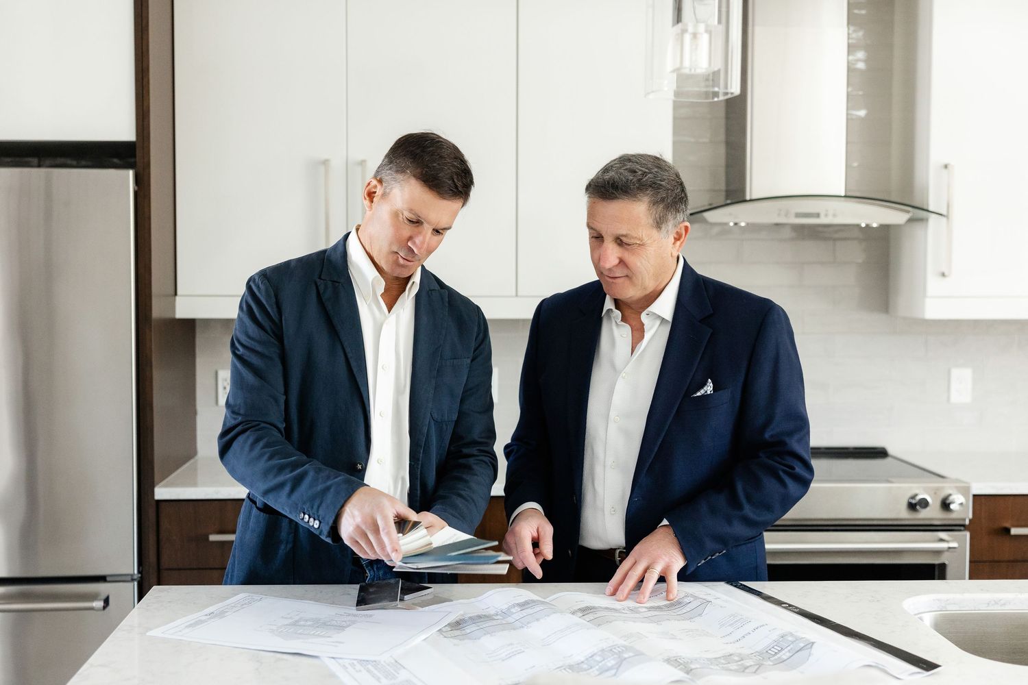 Business meeting with professionals discussing architectural drawings in modern office.