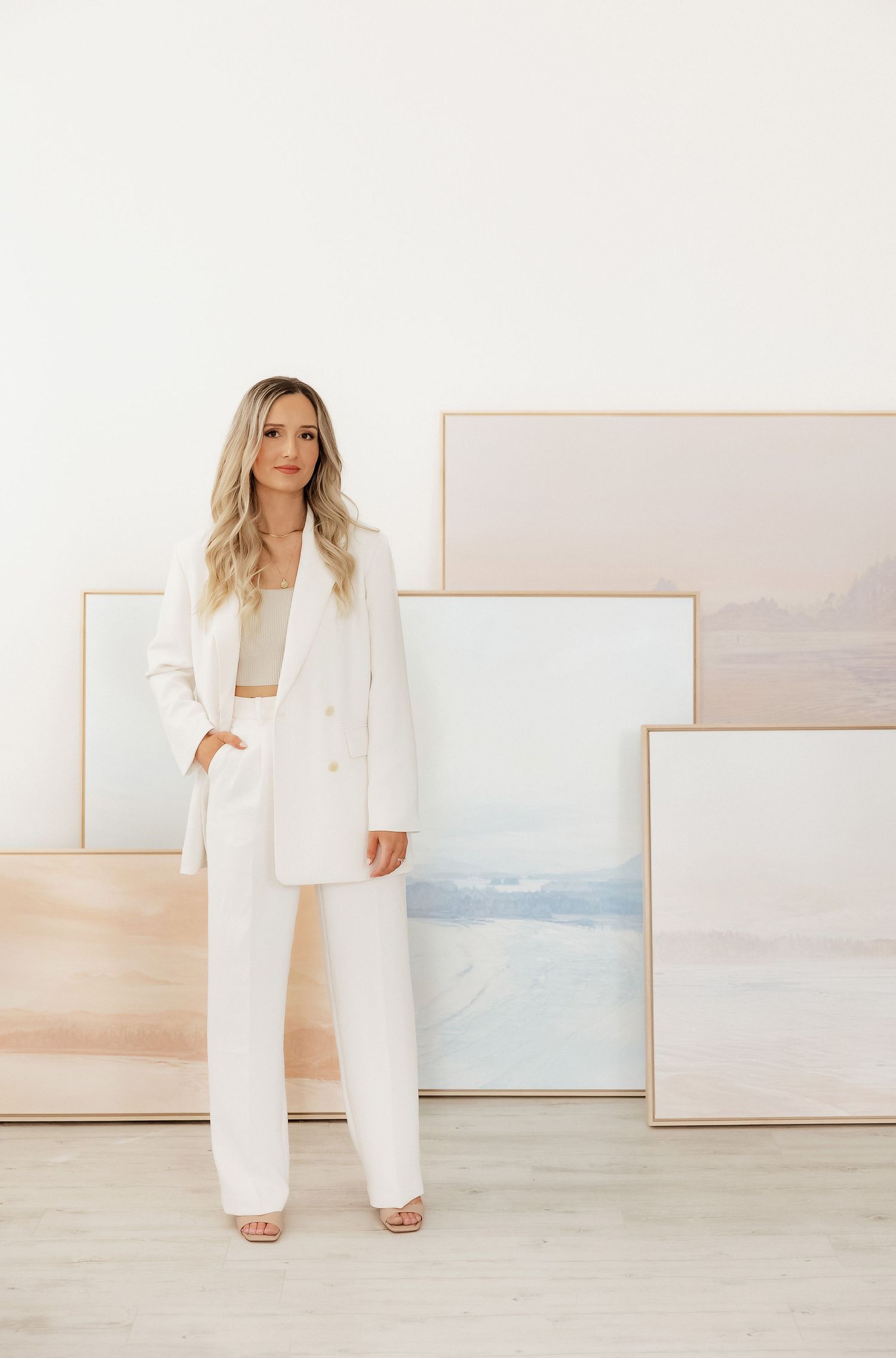Modern white outfit styled against minimal art gallery wall background.