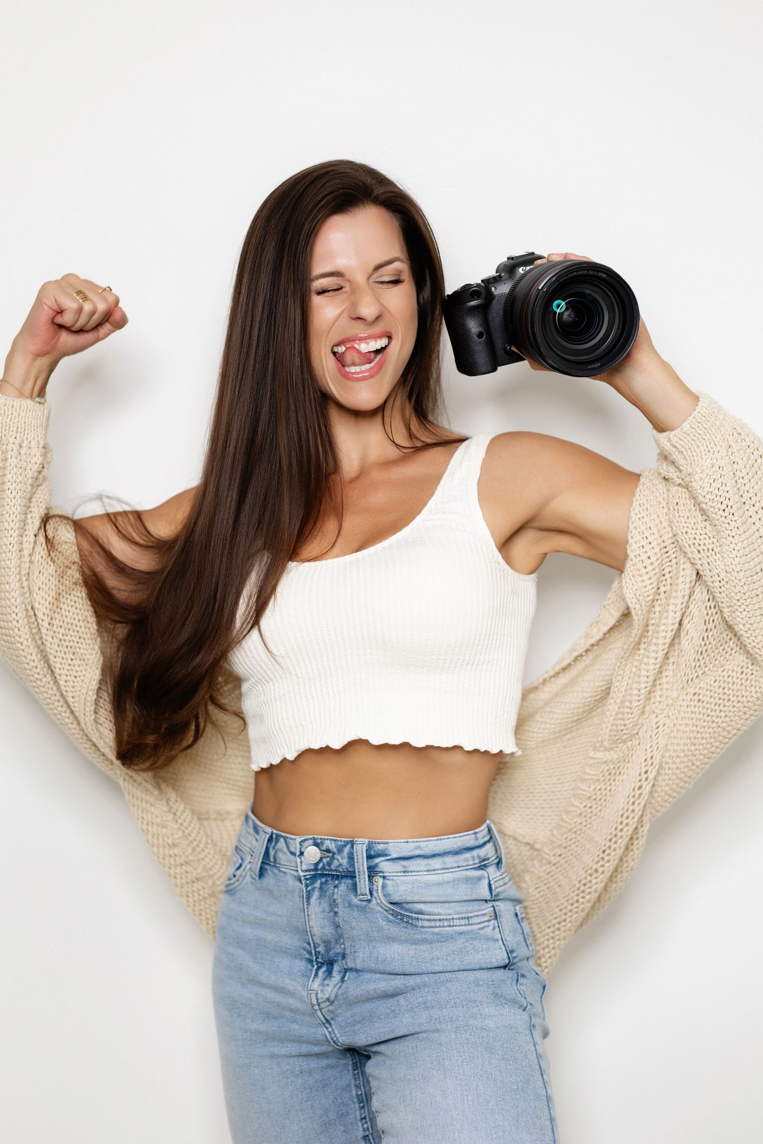 Energetic portrait series showing photographer in casual outfit with camera and sweater.