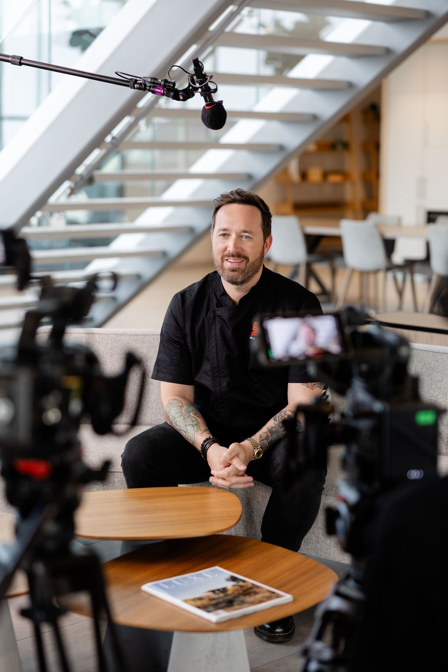 Behind the scenes photo shoot setup with cameras and lighting equipment in modern office space.