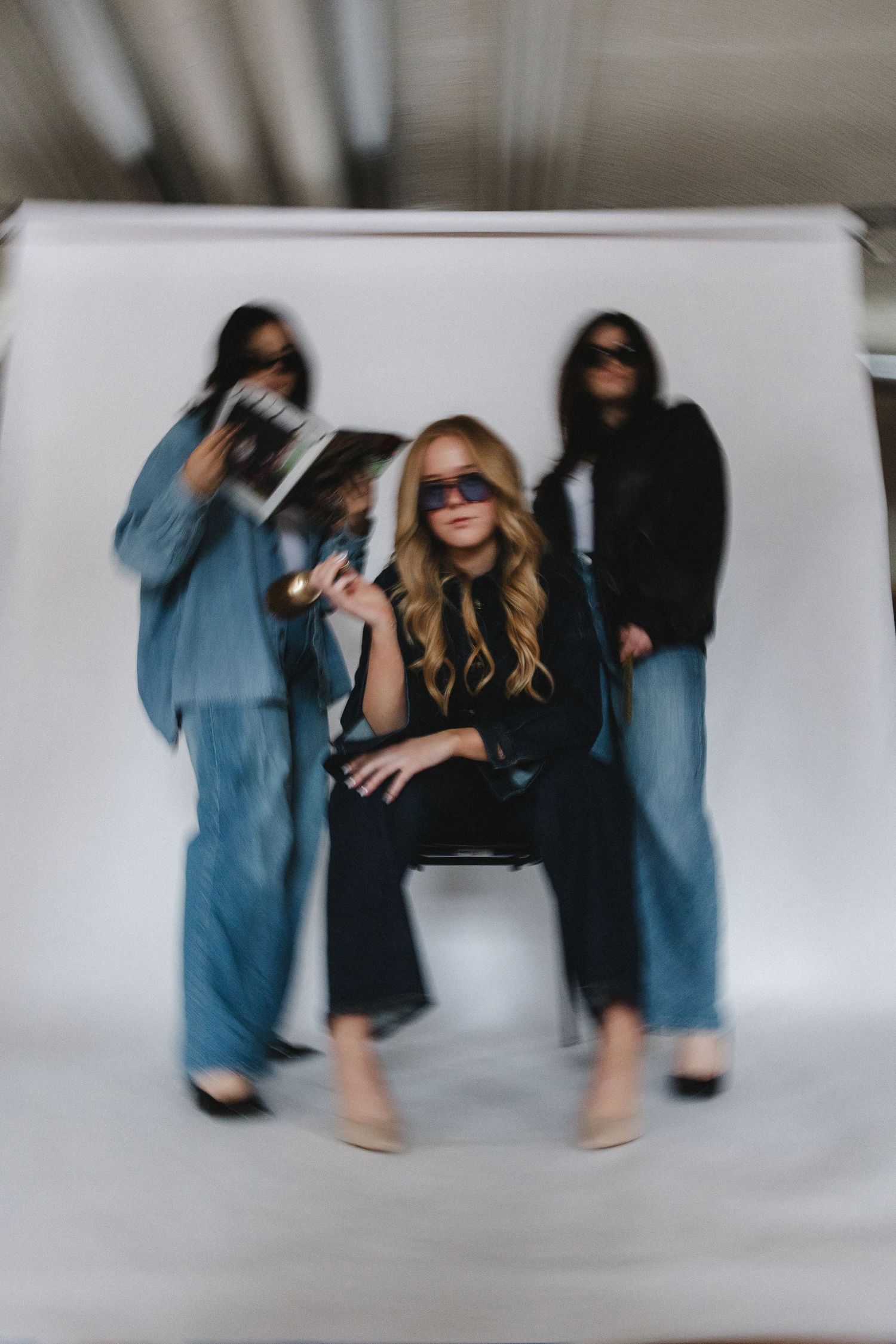 Artistic blurred motion photography with figures in denim and black clothing.