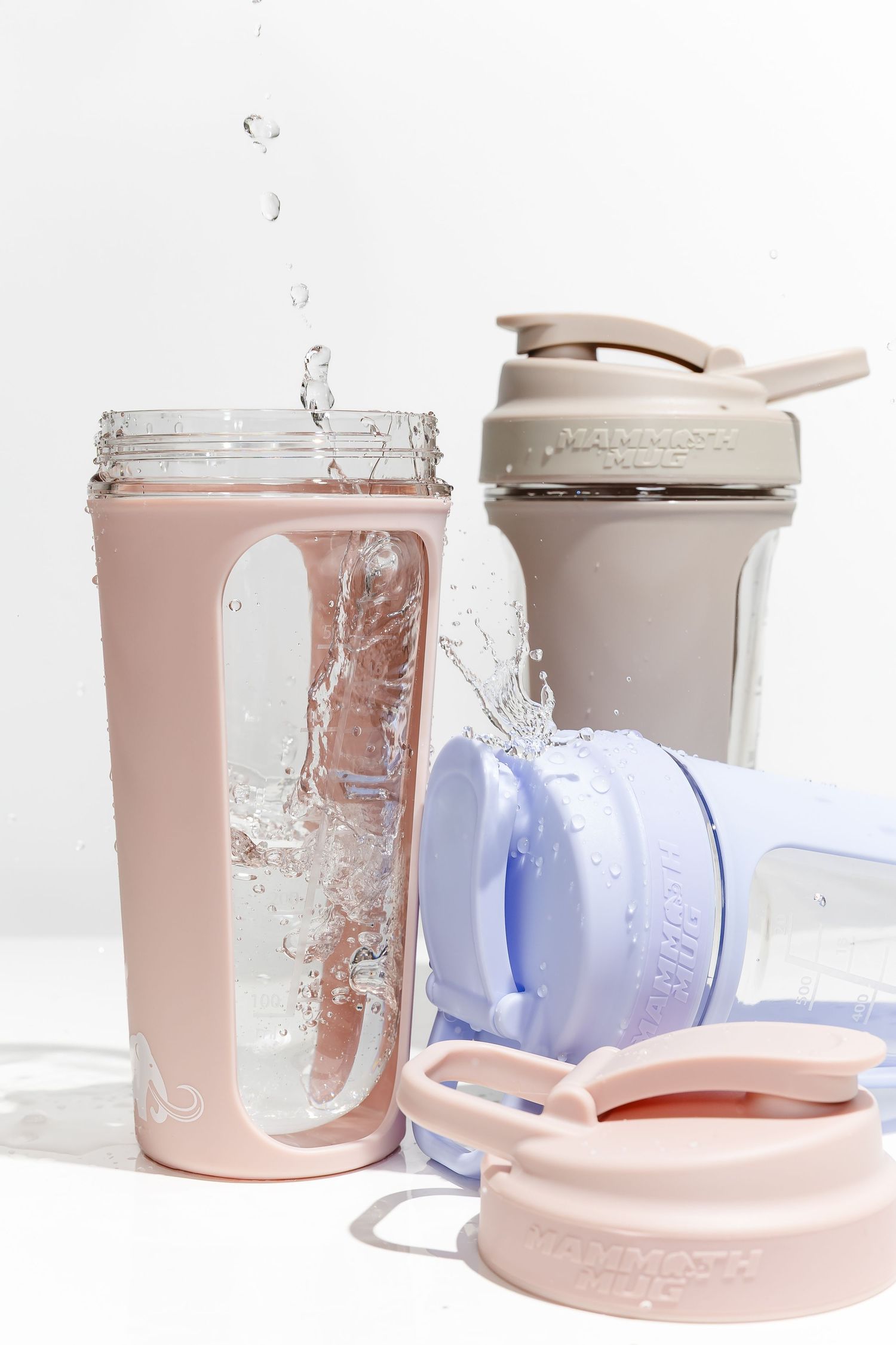 Water splashing inside pink and blue drink containers with clear viewing windows.