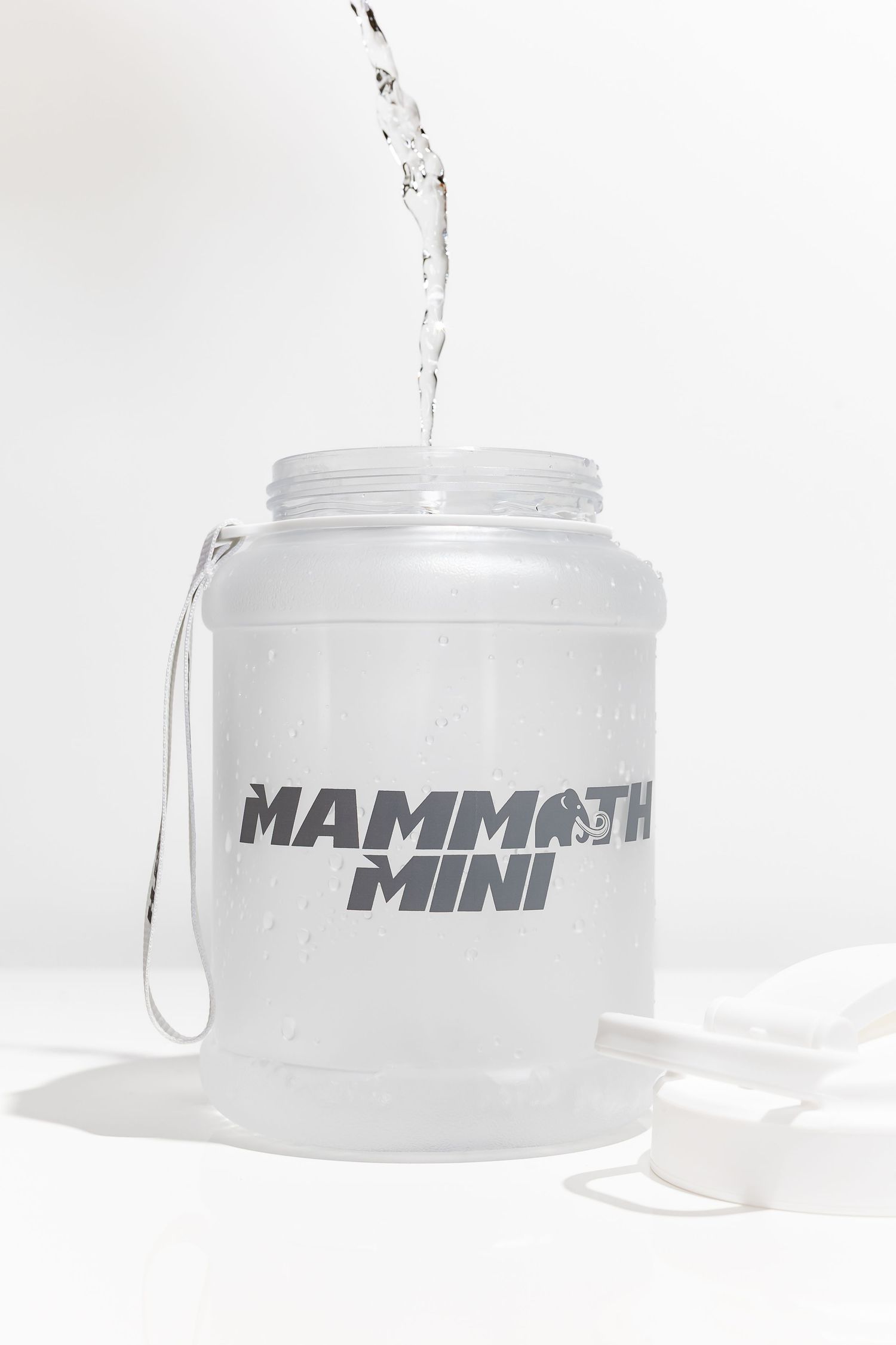 Water being poured into white Mammoth Mini containers against white background.