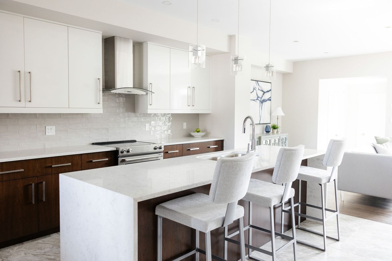 Contemporary white kitchen with bar seating and minimalist design elements.