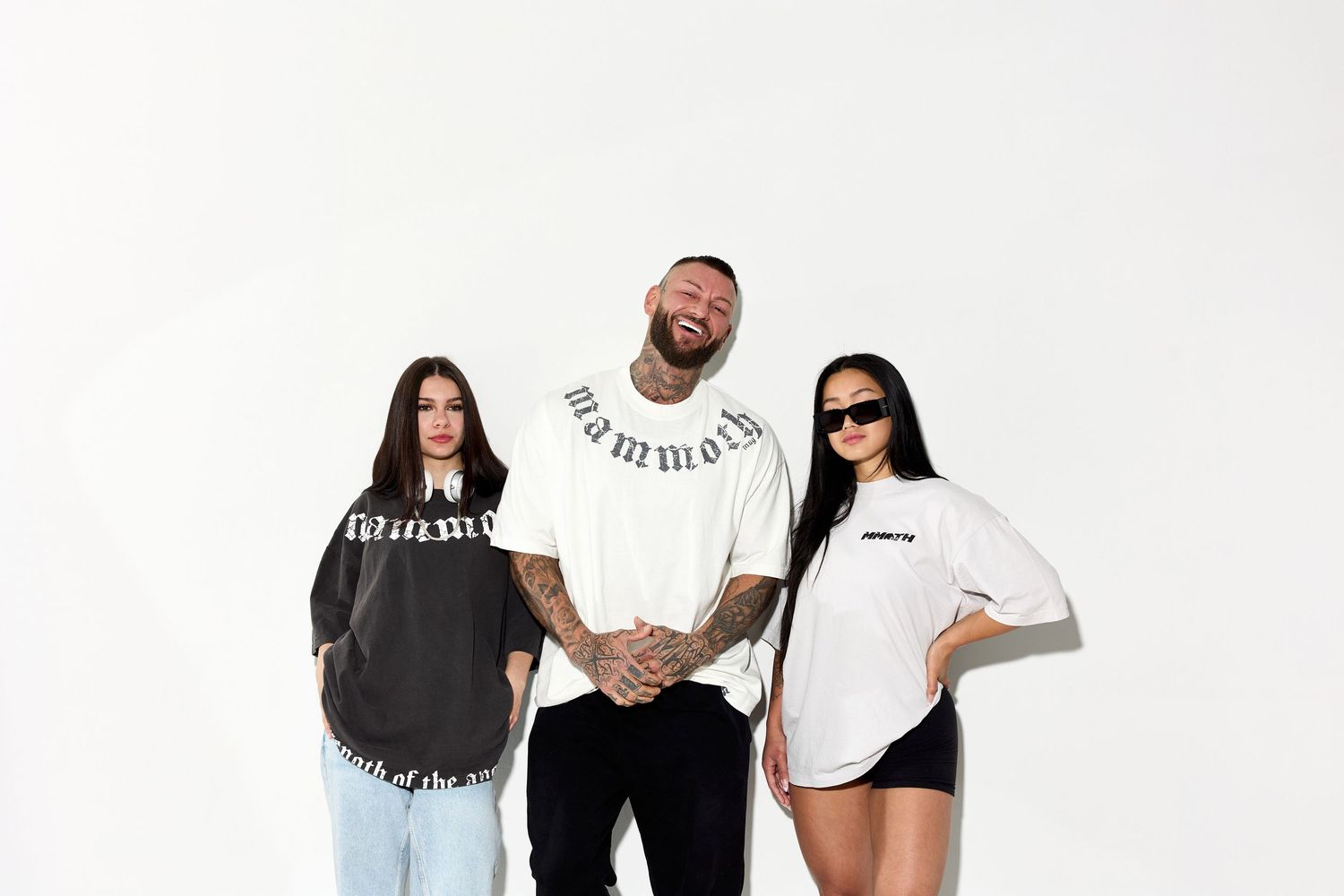 Group wearing white and black casual apparel posing against white background.