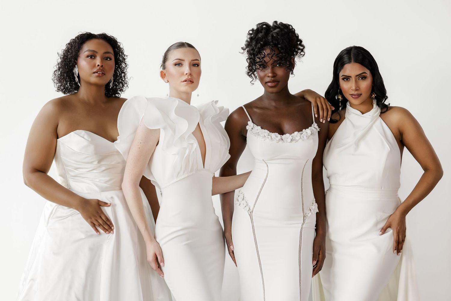 Collection of white wedding gowns arranged in a stylish fashion photoshoot setting.