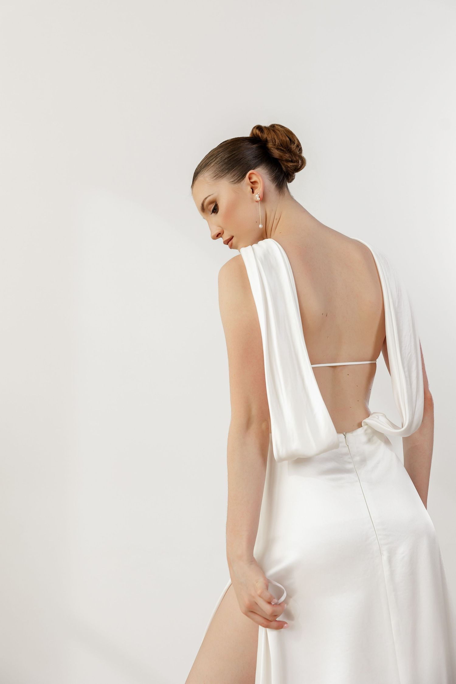 Classic white wedding dress with square neckline and open back shown from behind.