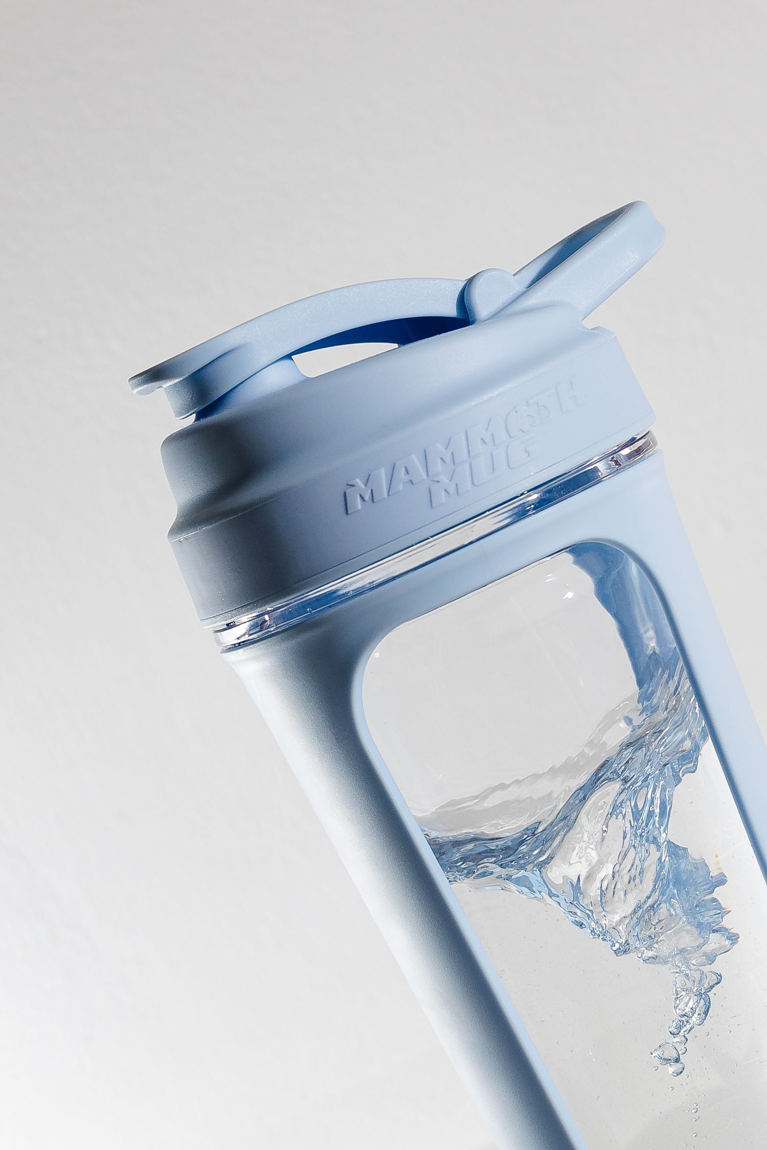 Light blue water bottle with splashing liquid captured in motion.