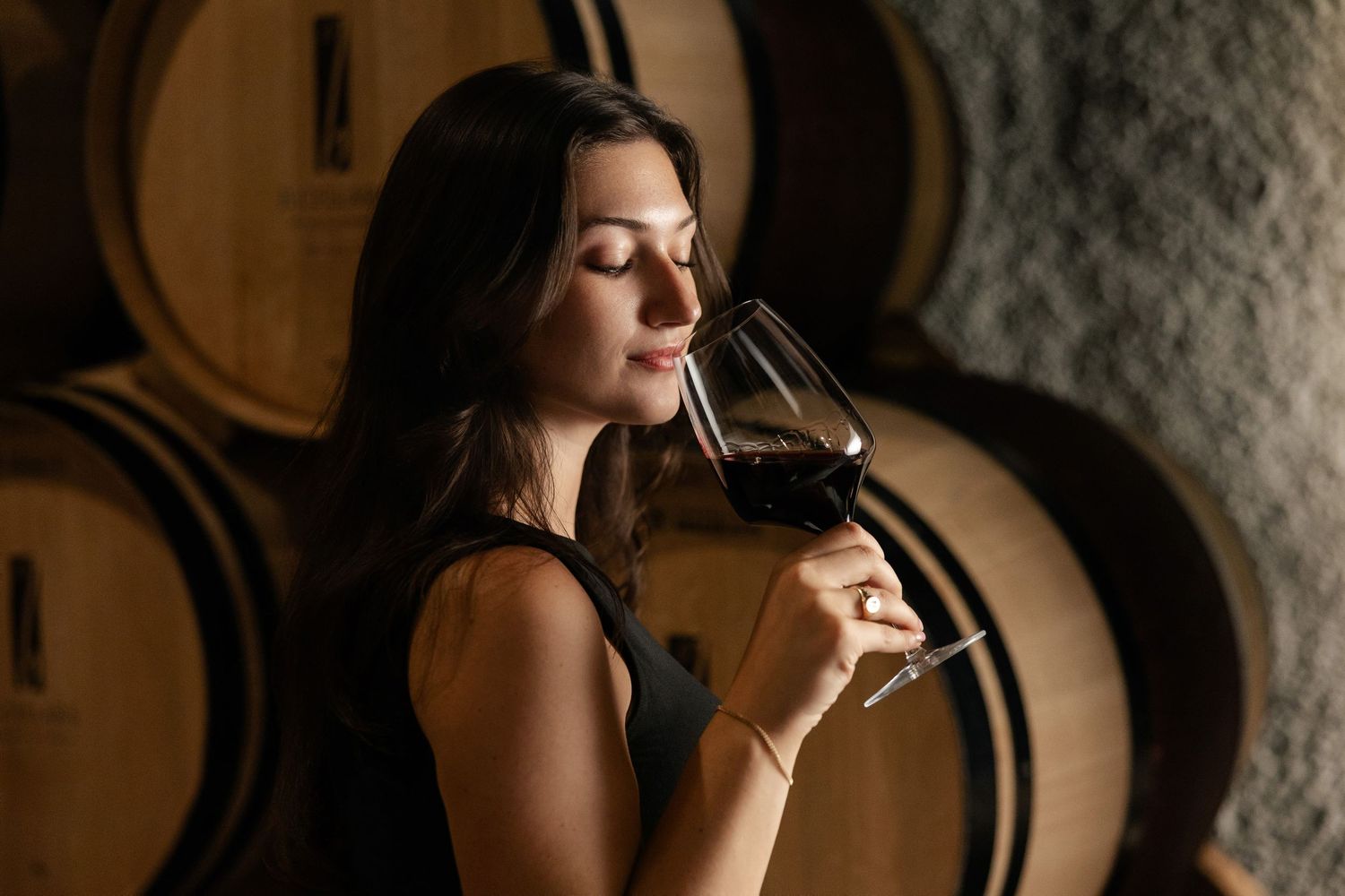 Wine tasting experience in a dimly lit cellar with oak barrels.