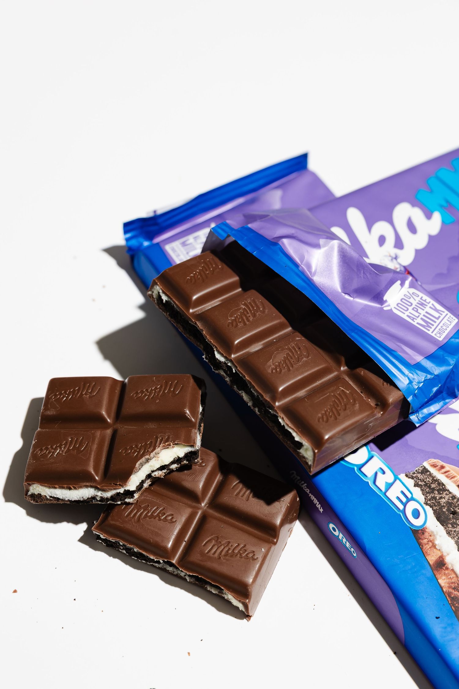 Chocolate bar segments with cream filling displayed next to blue packaging.