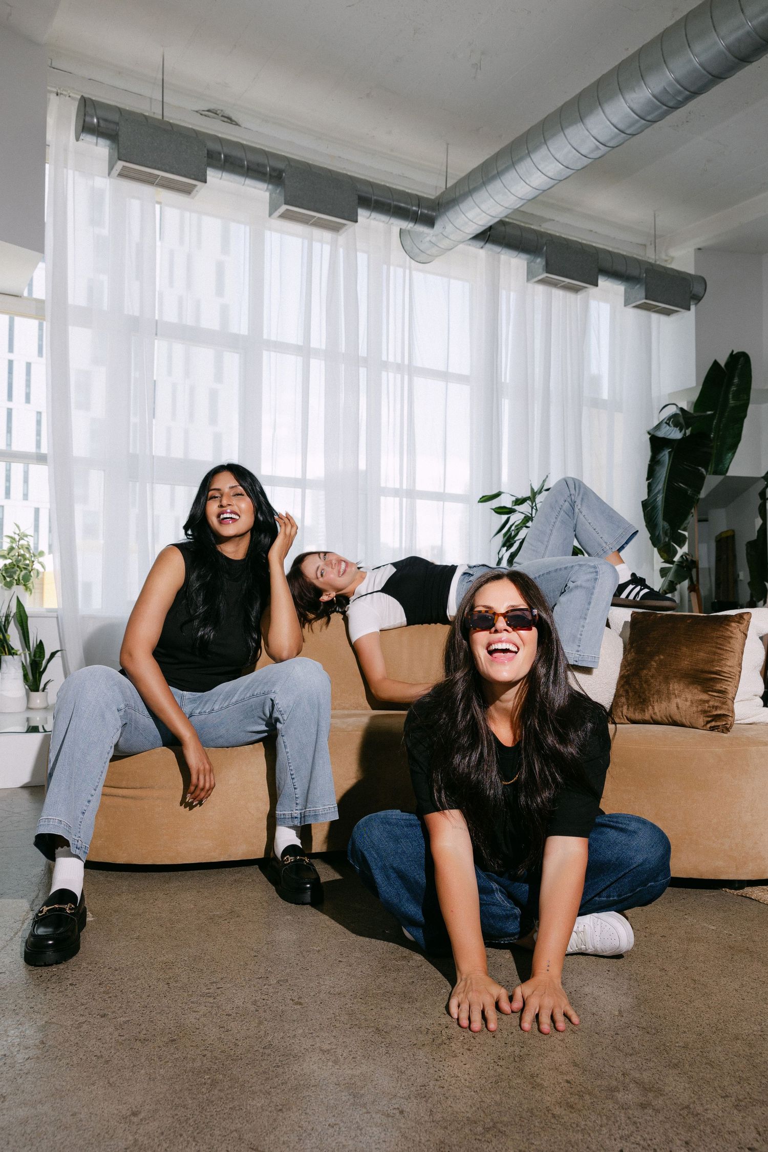Playful fashion photoshoot on a carpeted floor showing dynamic poses in casual attire.