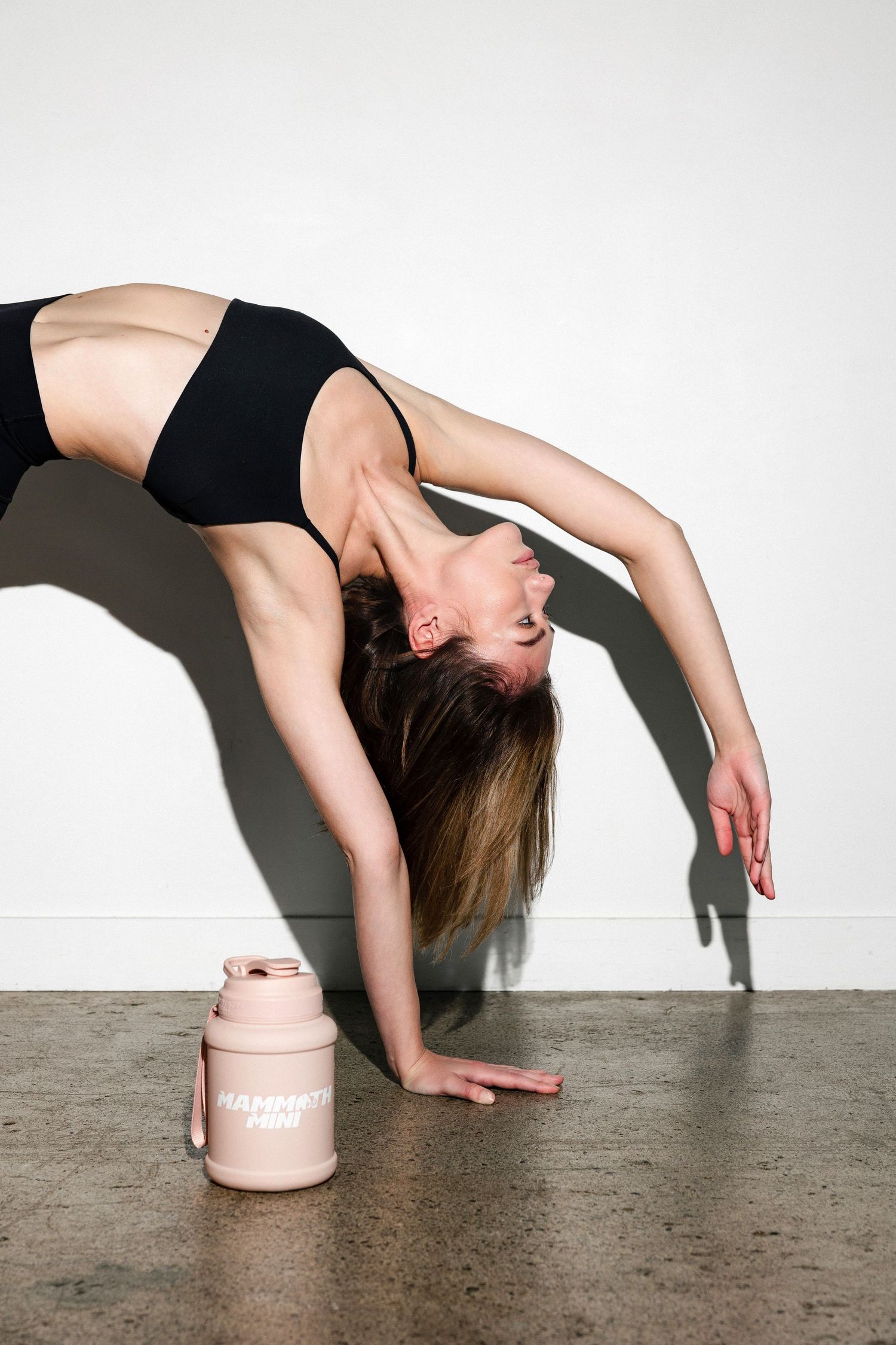 Dancer demonstrates graceful backbend movement sequence with pink container on floor.