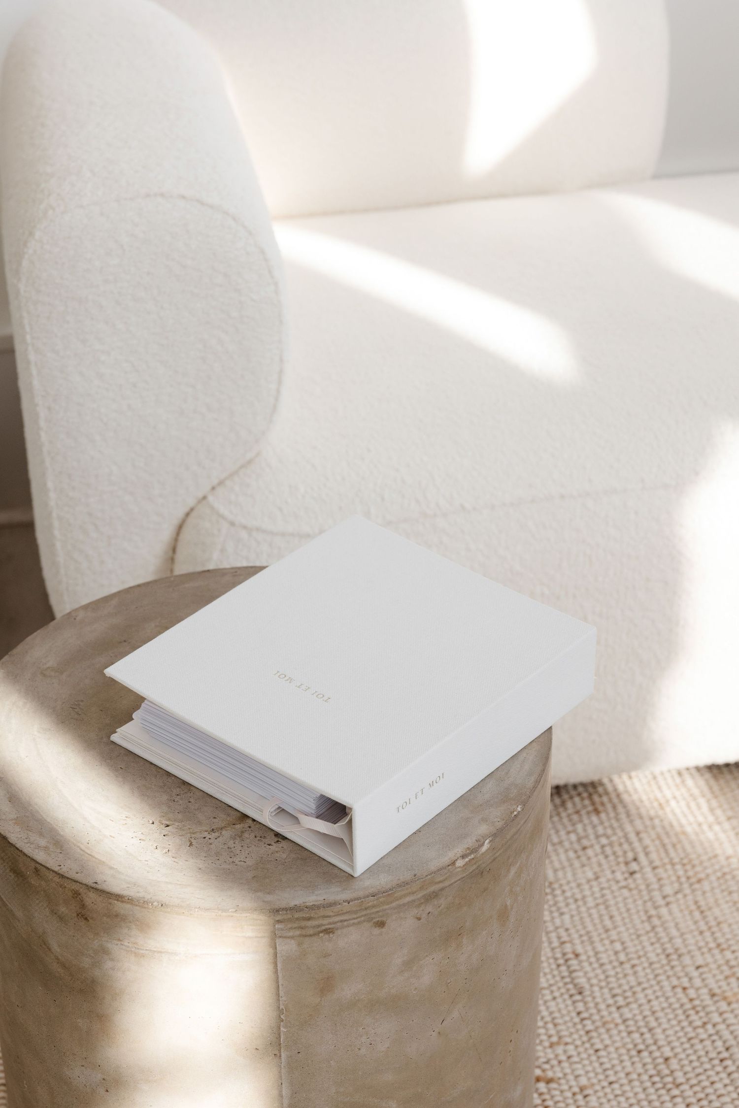 White paper or card casting soft shadows on concrete surface in natural light.