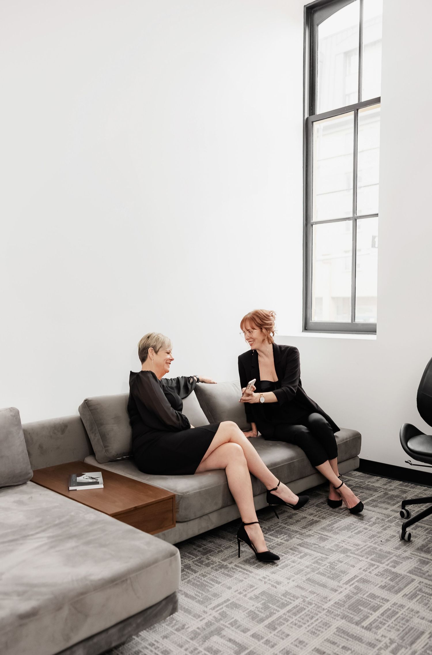 People relaxing on a gray couch during a retail consultation in a modern space.