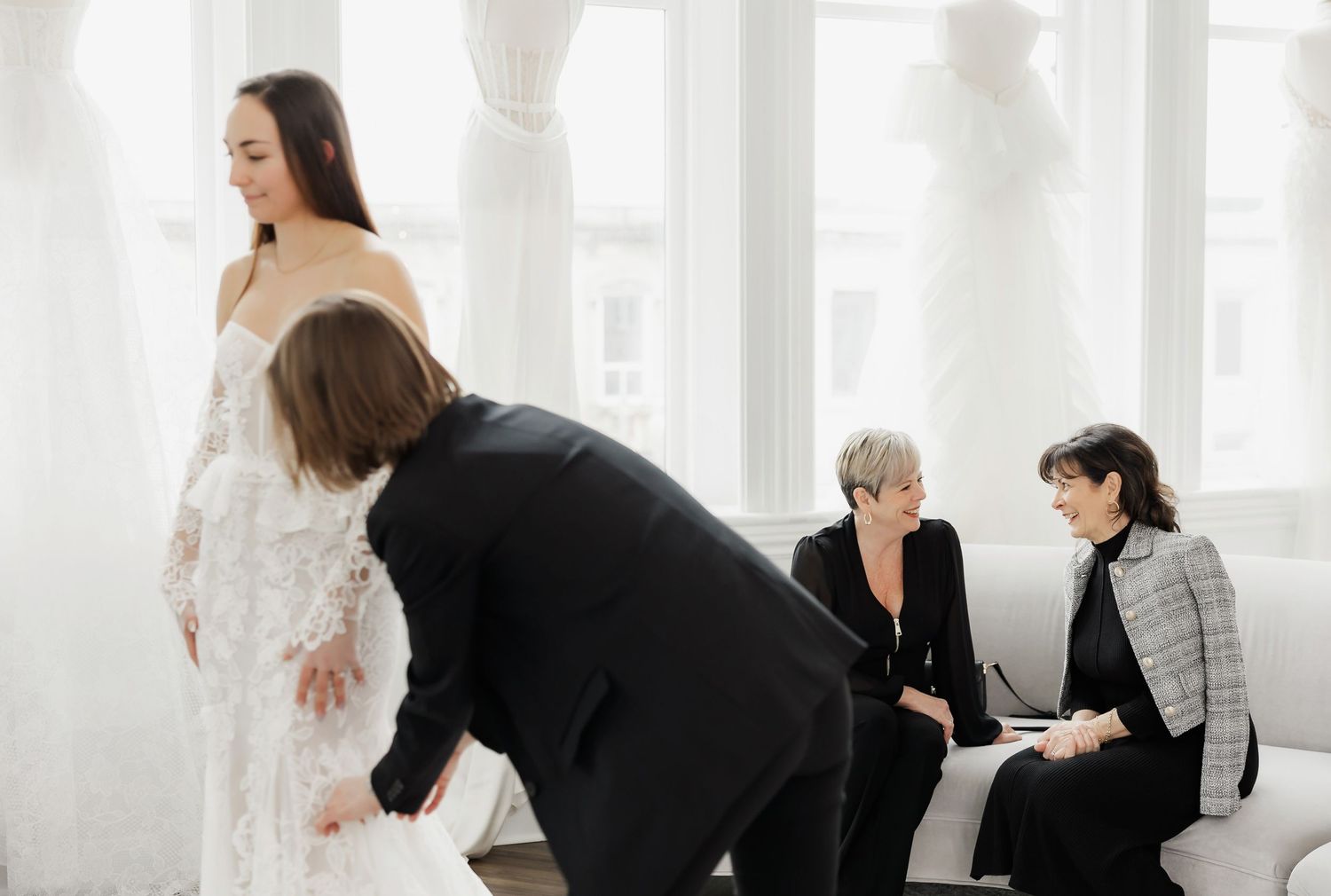 Bridal fitting session with consultants in an all-white luxury boutique space.