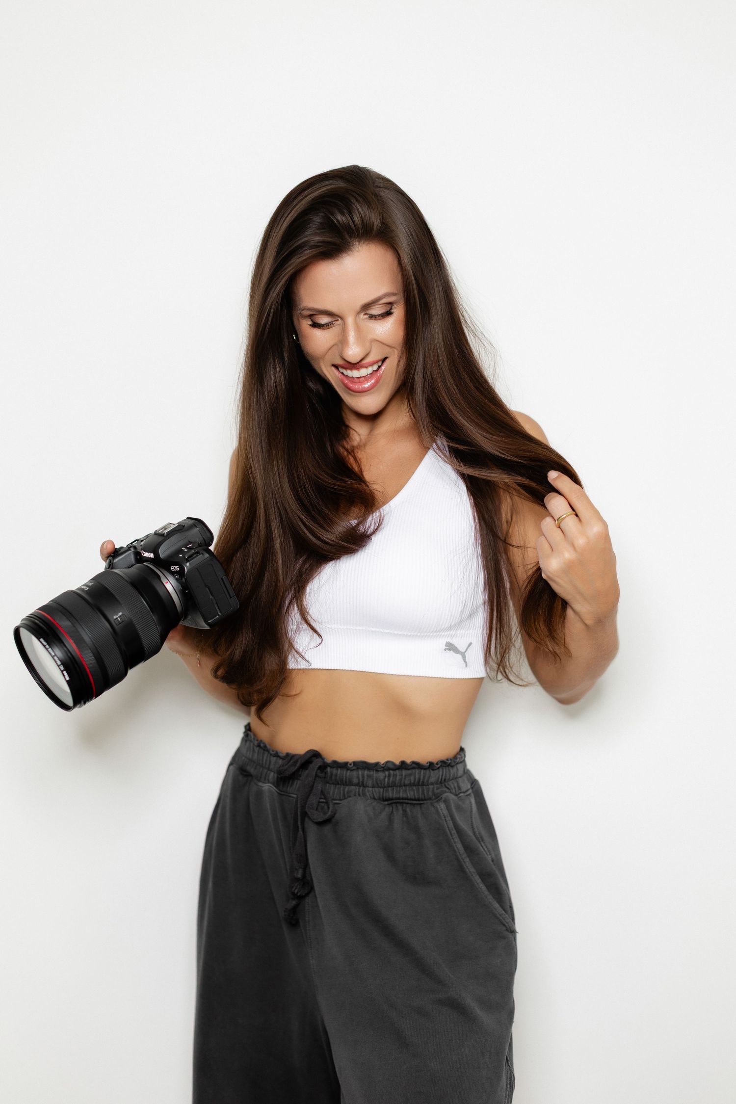 Casual portrait series showing photographer with camera wearing white crop top and dark pants.