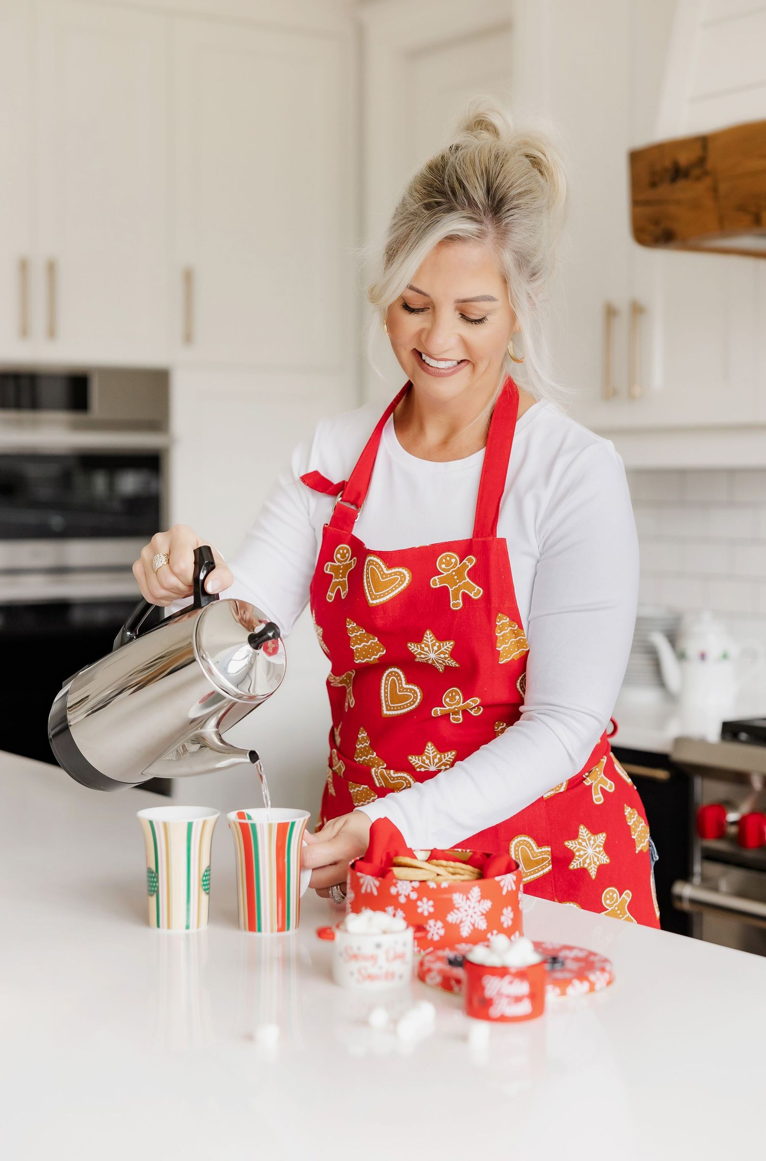Festive kitchen scene with red gingerbread apron and silver coffee carafe.