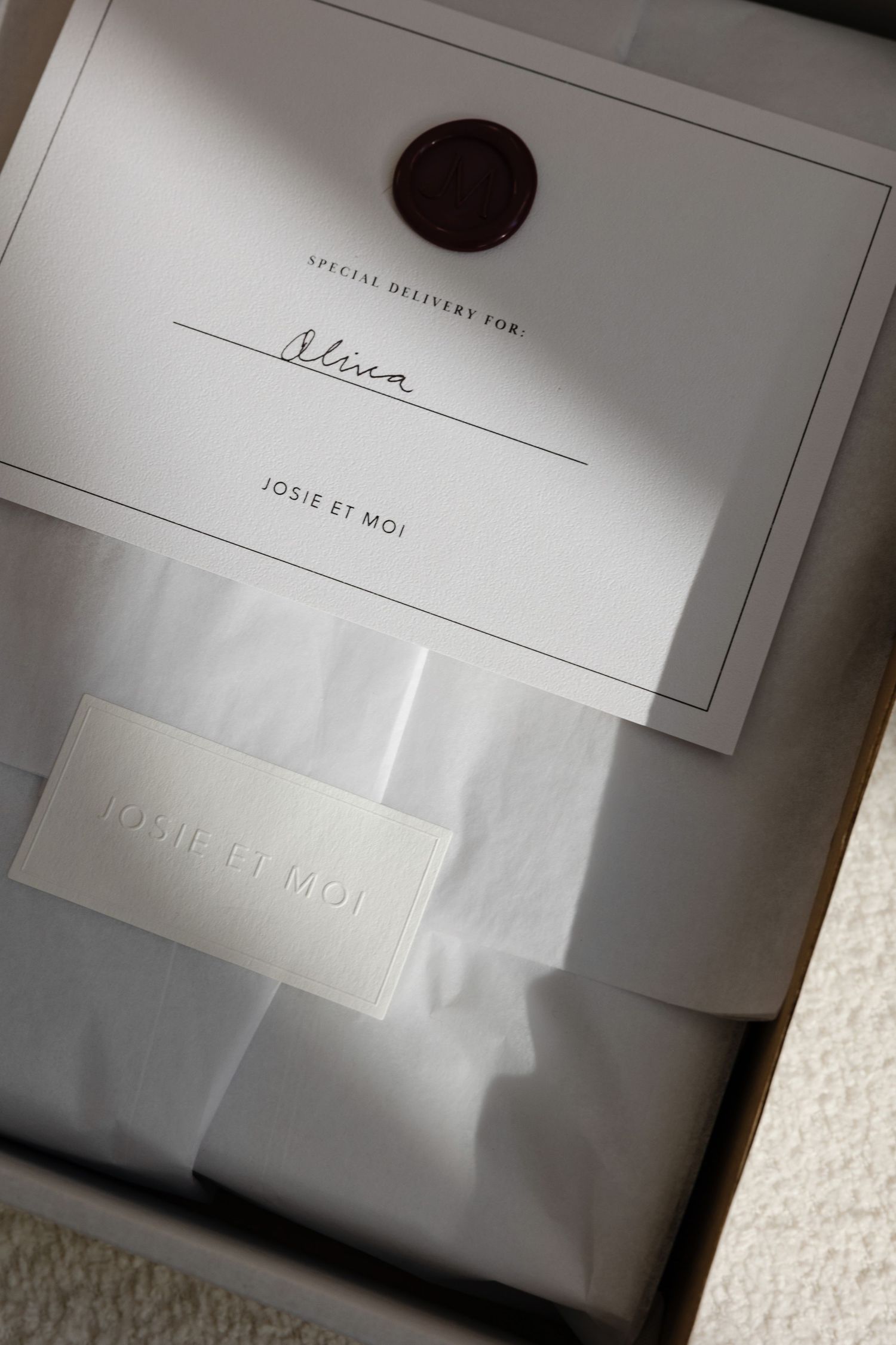 Elegant white stationery with embossed details and wax seal in modern minimalist design.