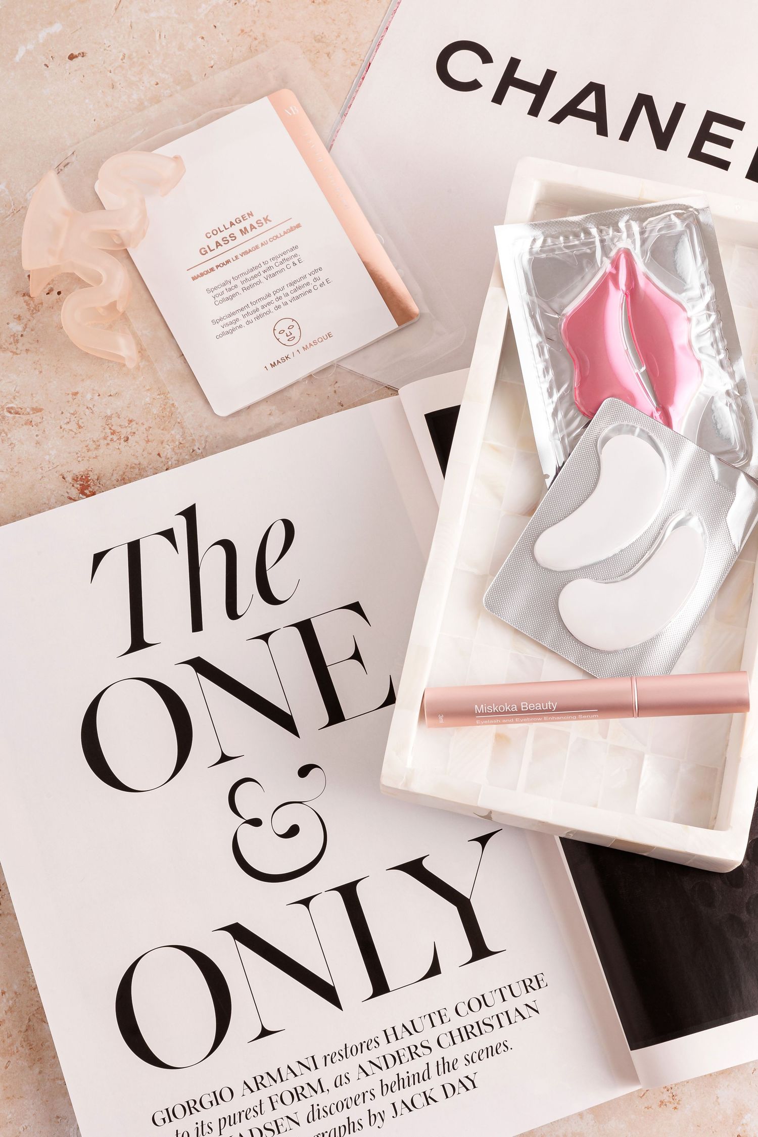 High-end beauty products and eye patches arranged with fashion magazine layouts.