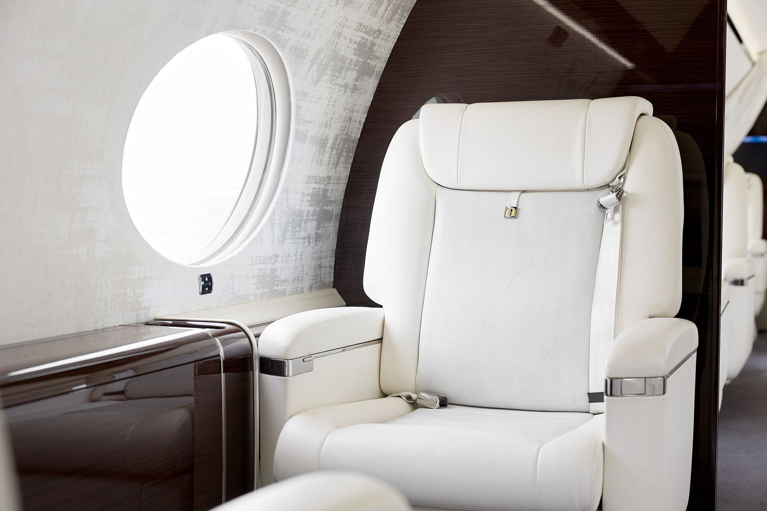 White leather seats and cabin interior details of a modern private aircraft.