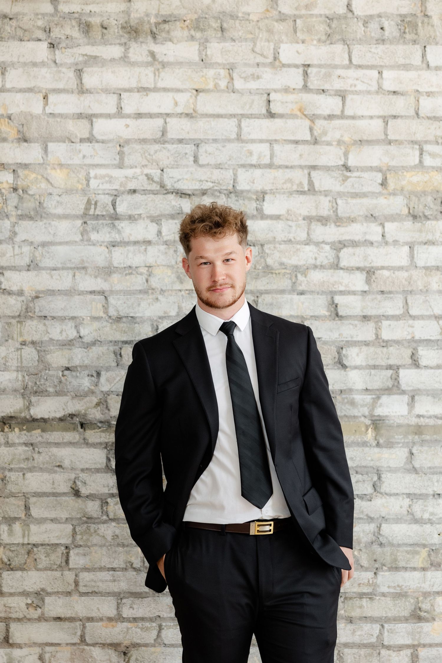 Professional portrait session against white brick wall background.