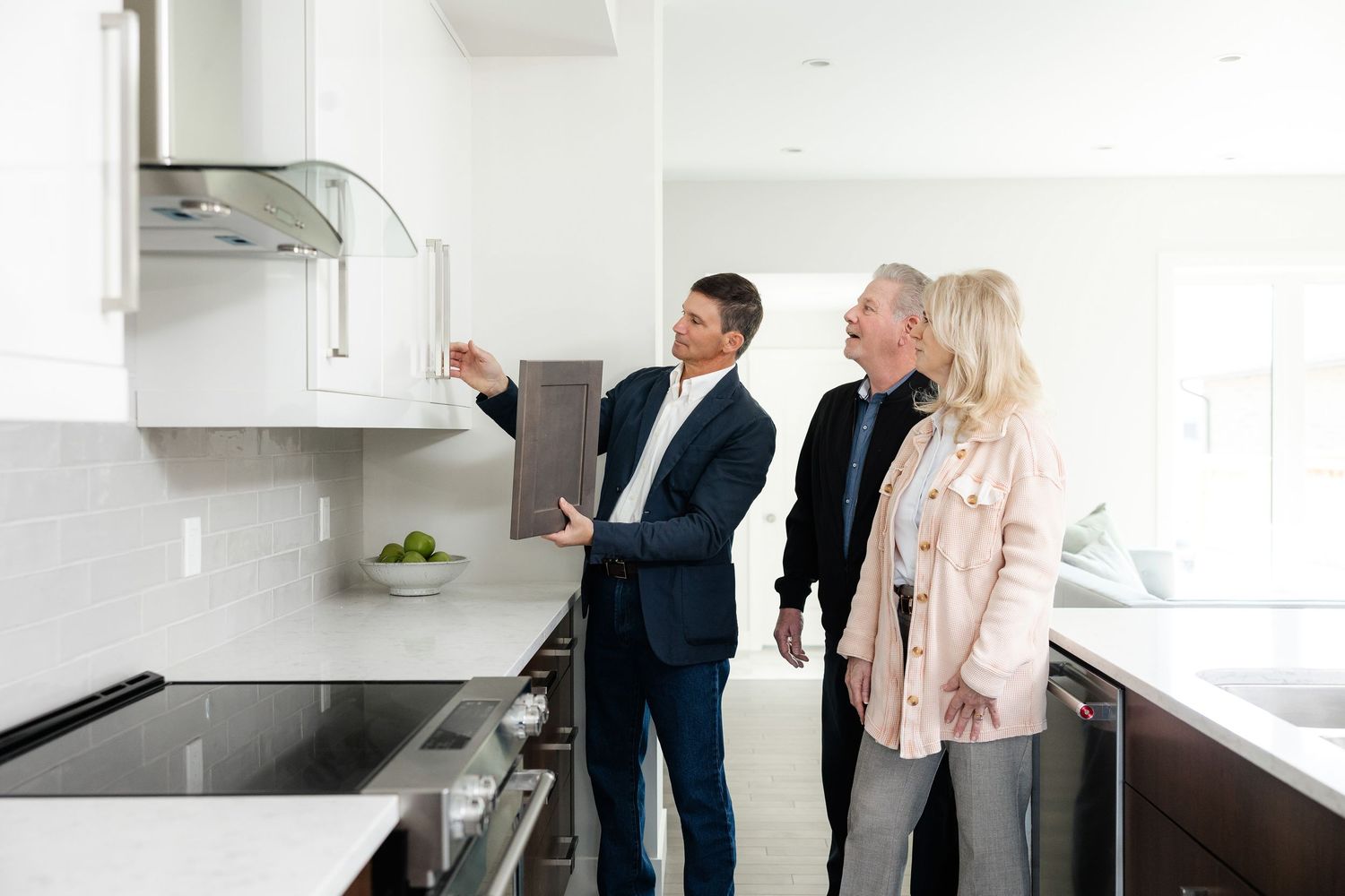 Group discussing features of modern kitchen design during property tour.