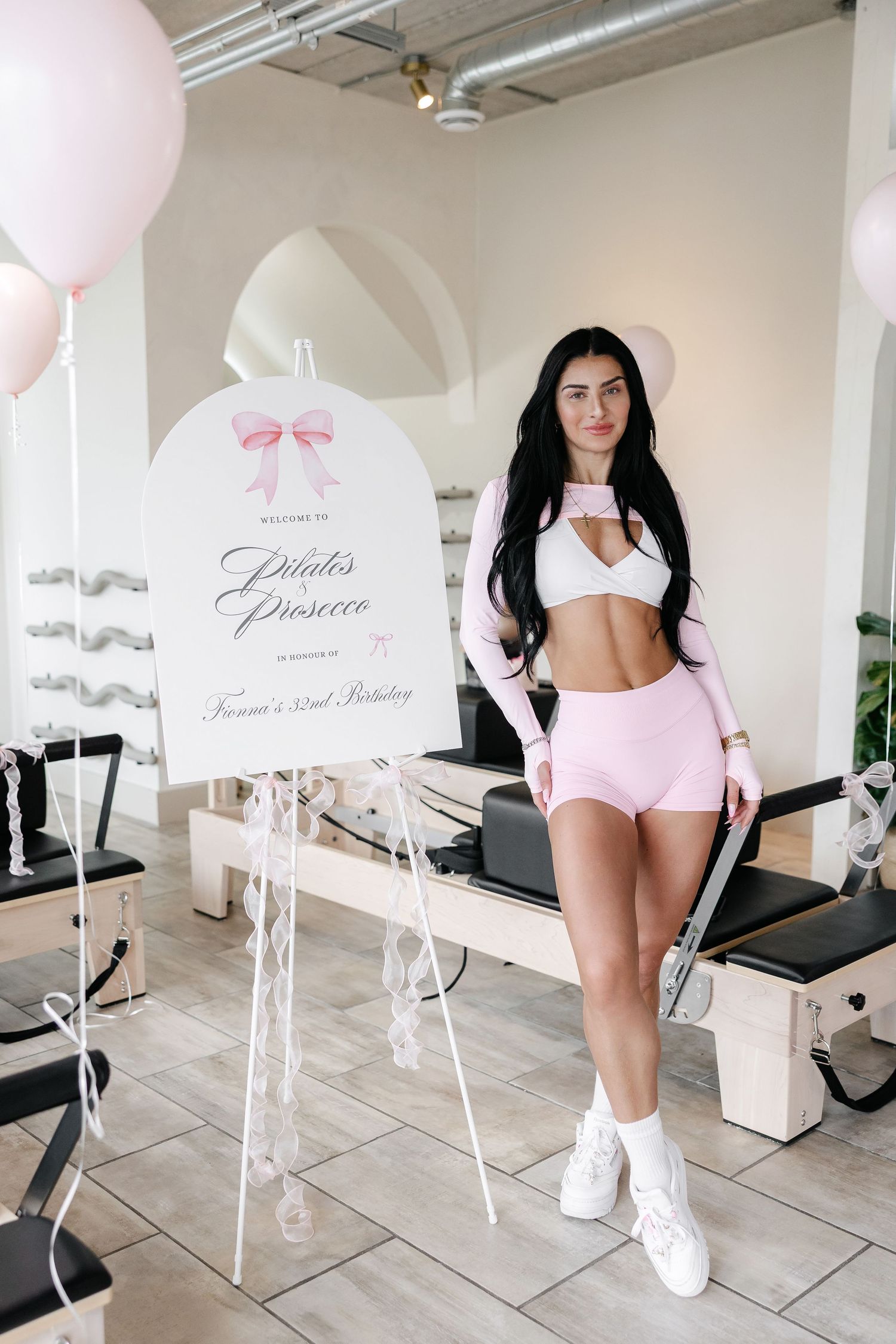 Fitness studio interior with pink balloons and decorative signage.