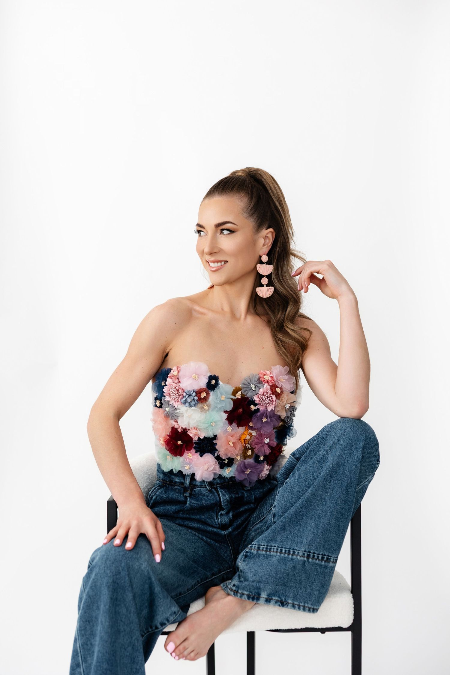 Casual fashion look combining floral corset top with relaxed denim in studio setting.
