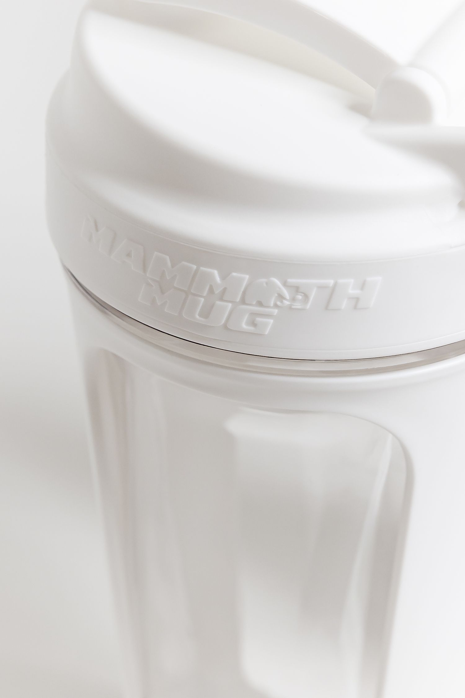 White Mammoth Mini drink container photographed in soft focus against light background.