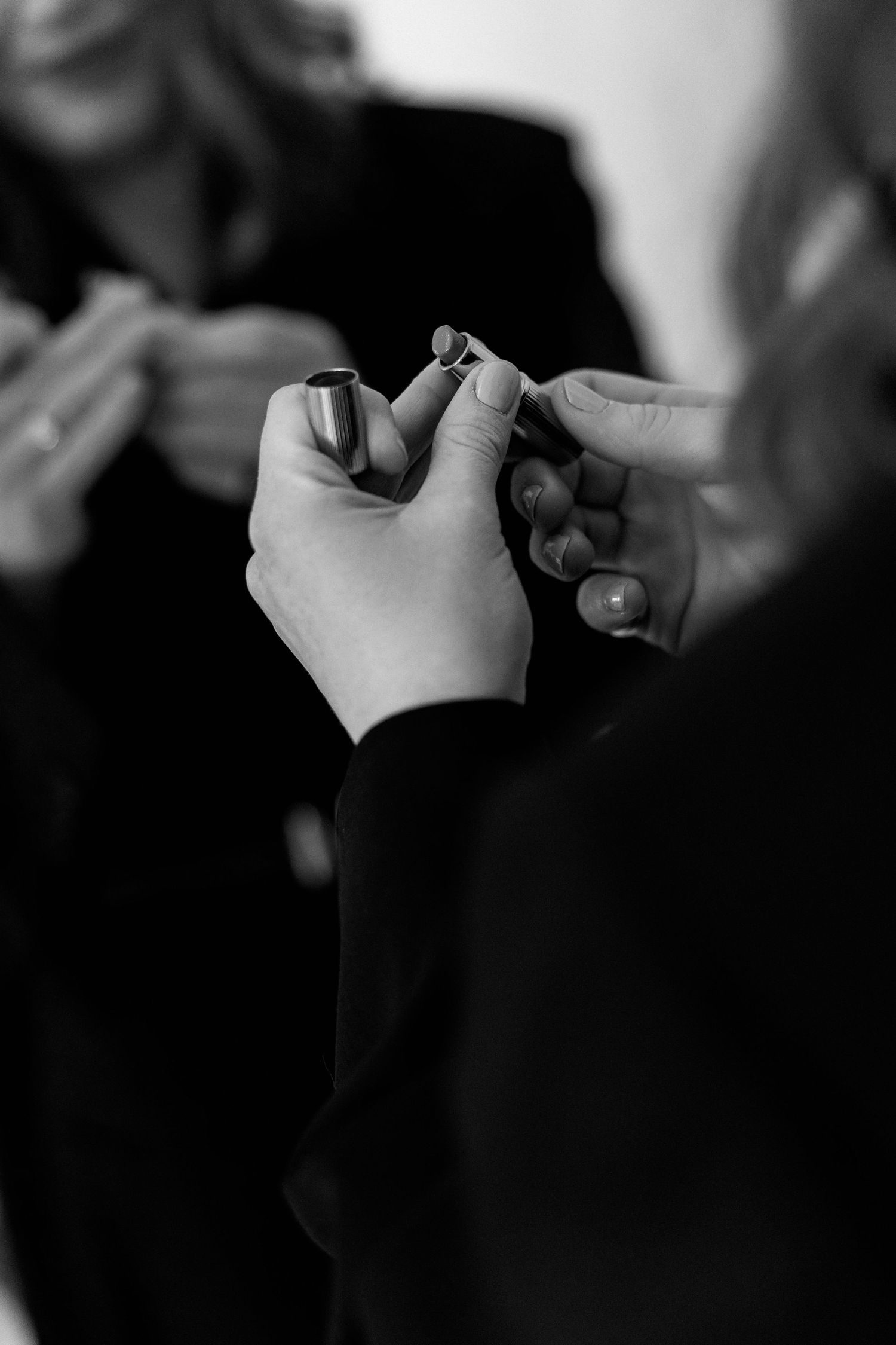 Black and white close-up of hands holding small objects.