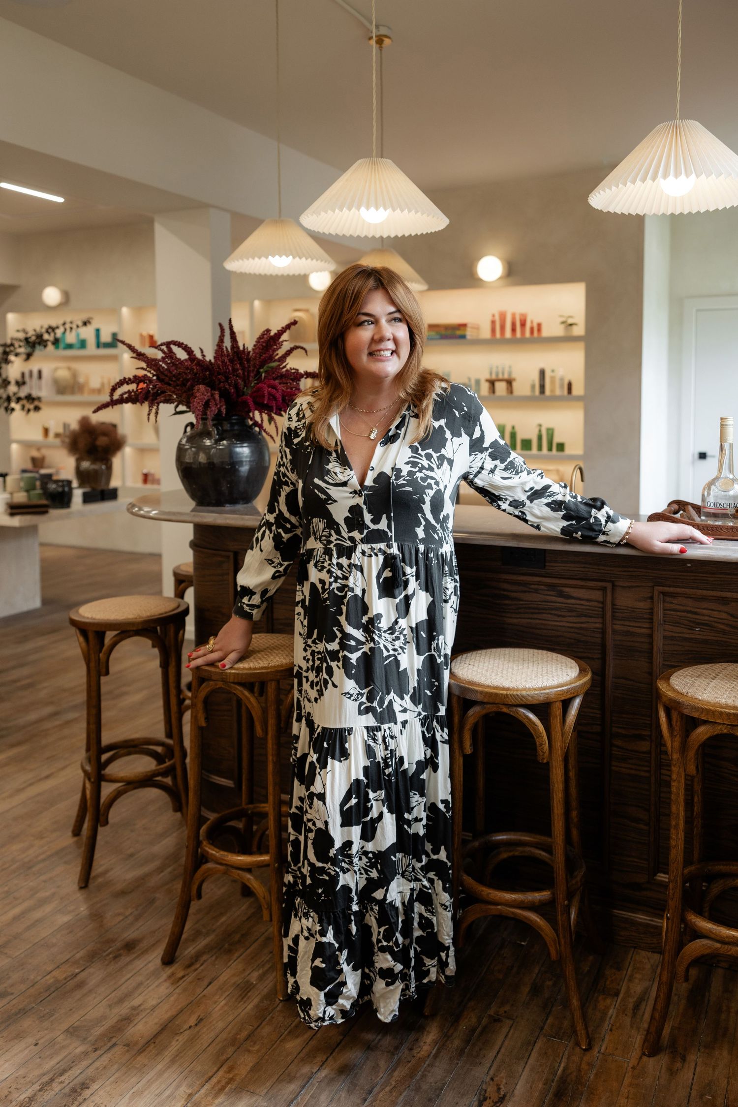Modern salon interior with black and white floral decor and wooden bar seating.