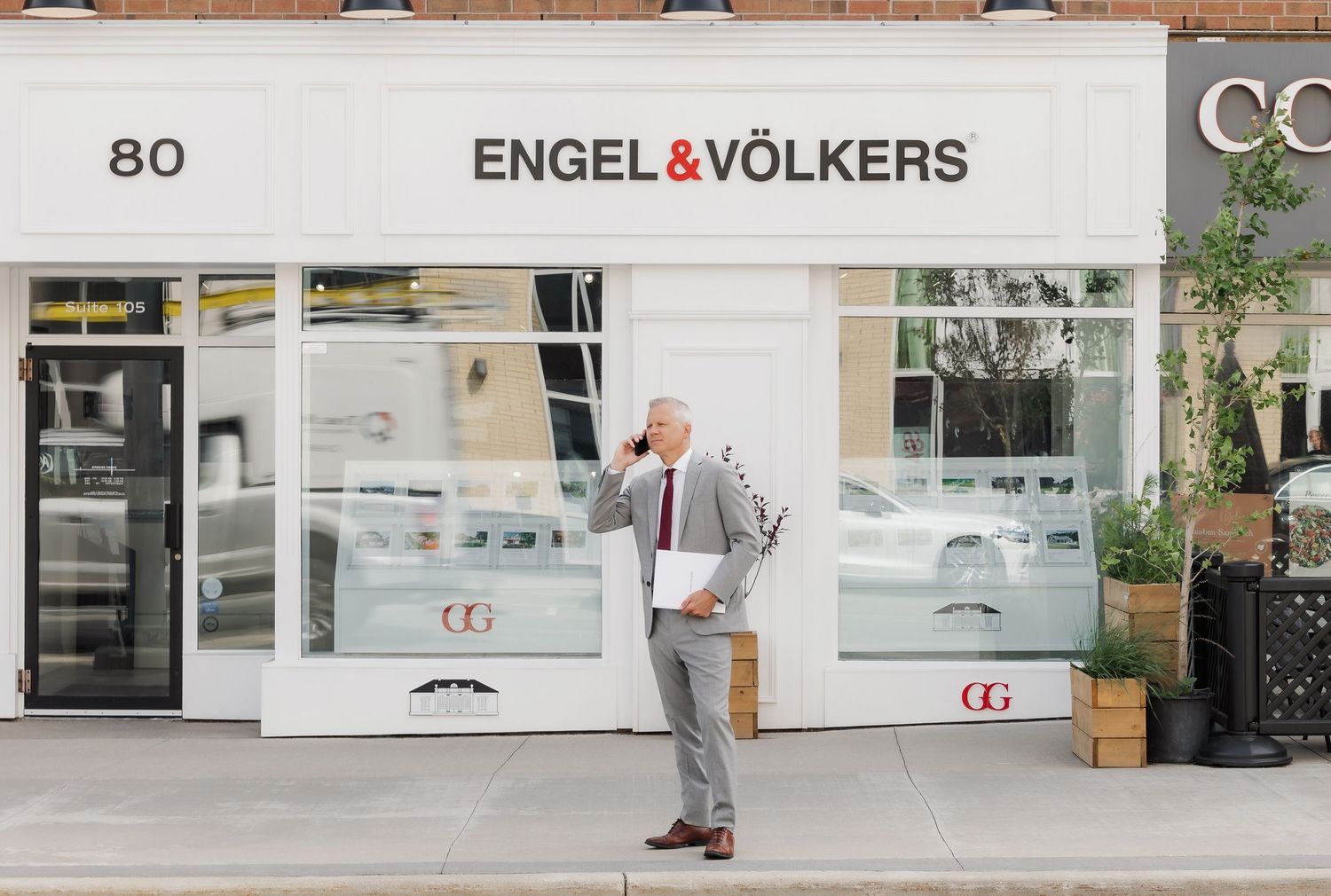 Street view of Engel & Volkers real estate office with modern storefront design.