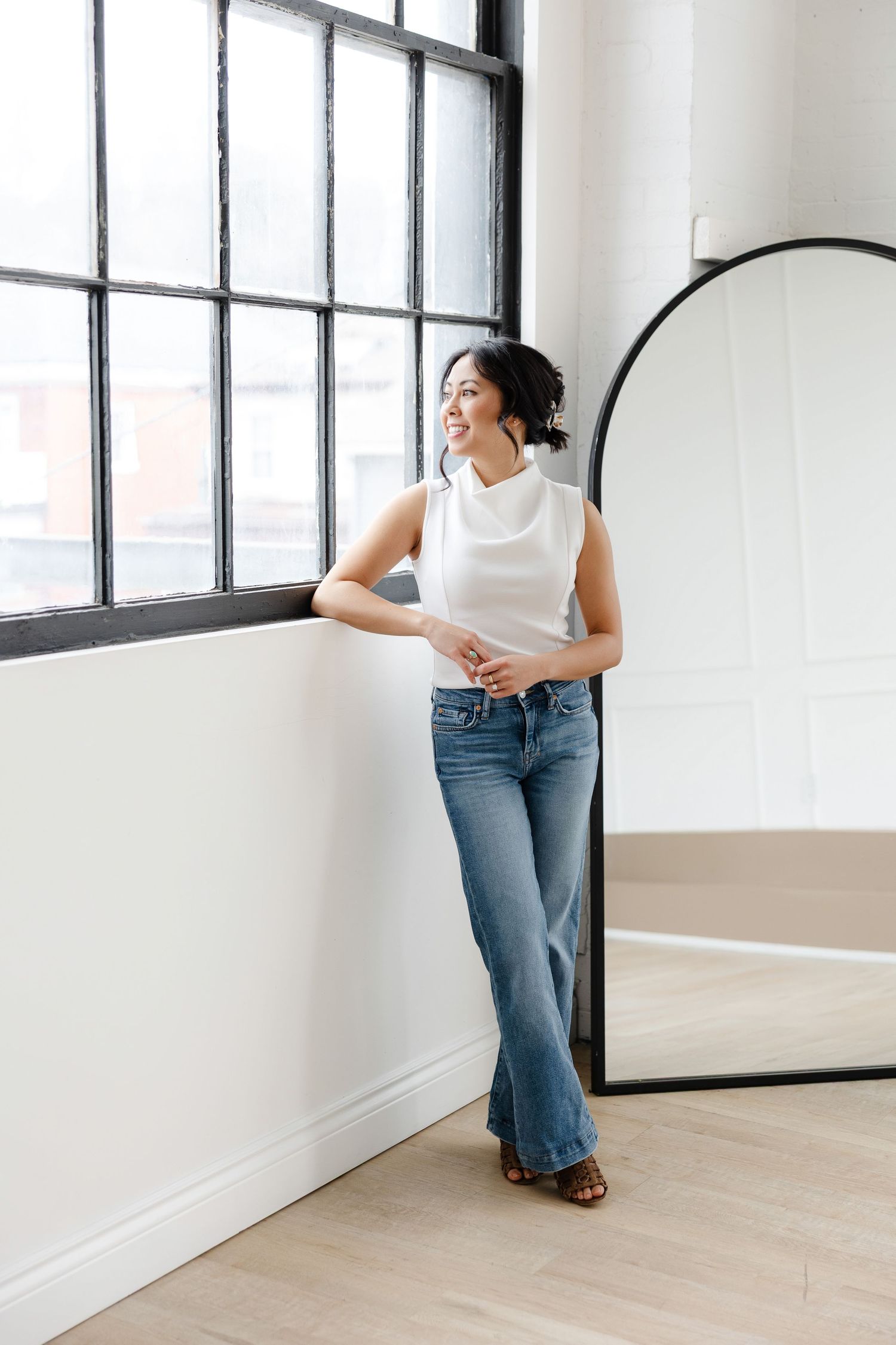 Candid studio photography against white walls and large industrial windows.