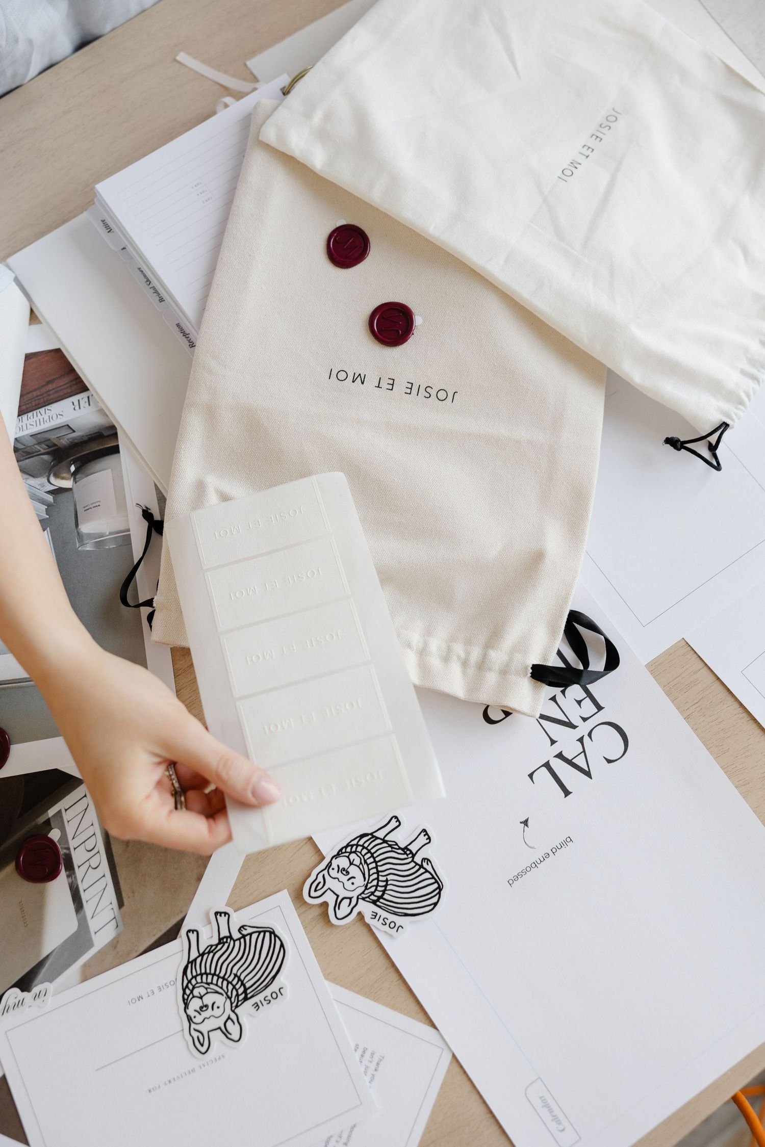 White paper envelopes and cards with cat illustrations scattered on a wooden surface.