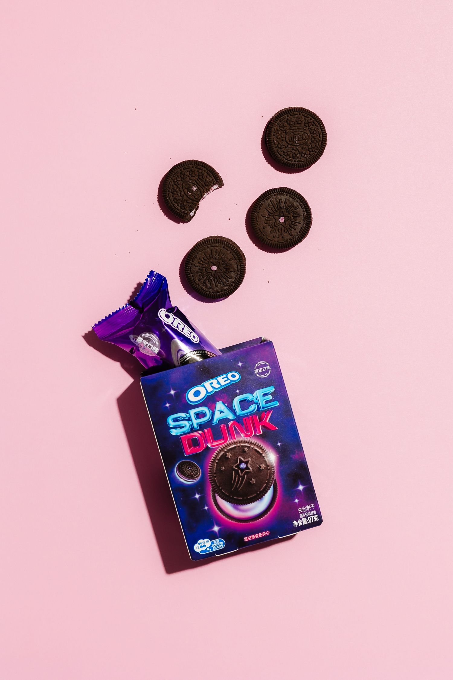 Oreo Space Play cookie package with scattered cookies on pink background.