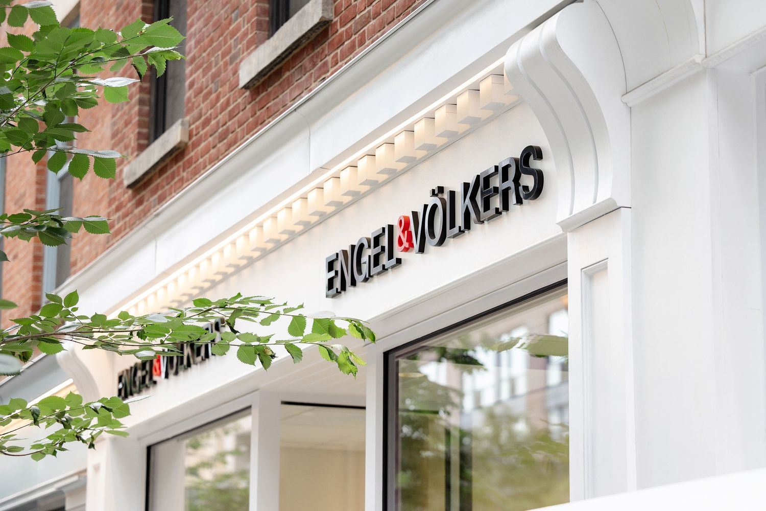 Modern white storefront with Engel & Volkers signage and classic architectural details.