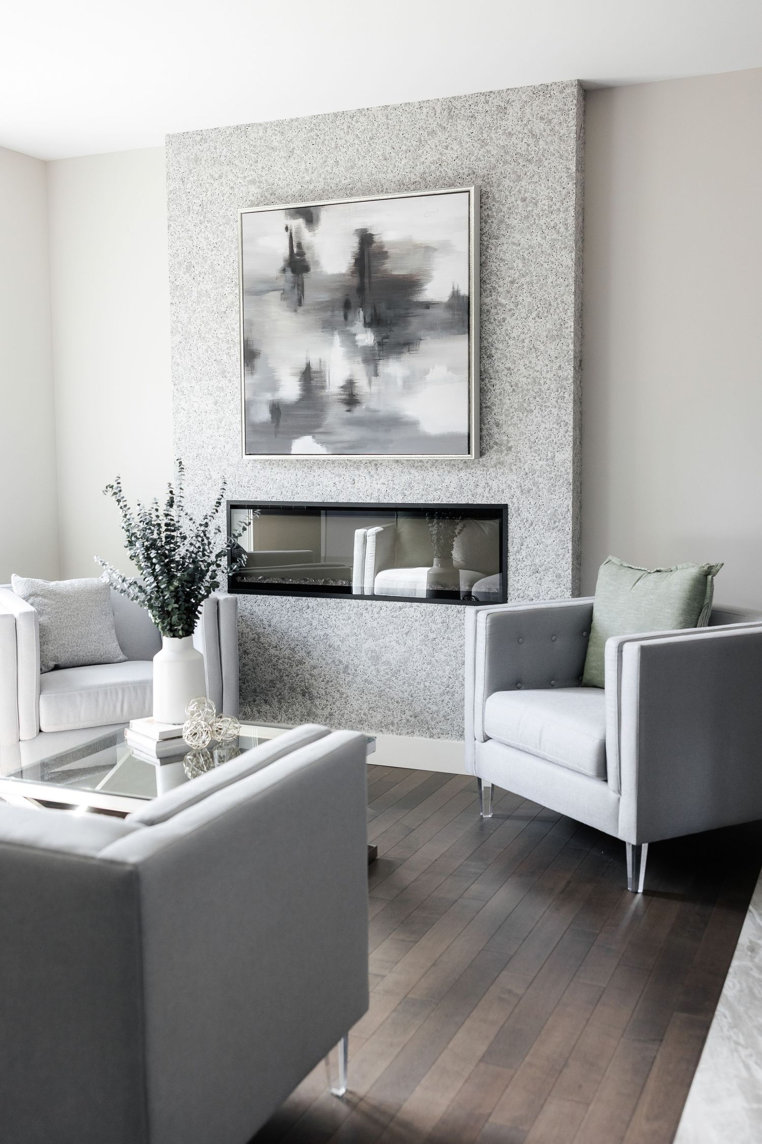 Modern living room with grey furniture, sparkle wallpaper, and hardwood floors.