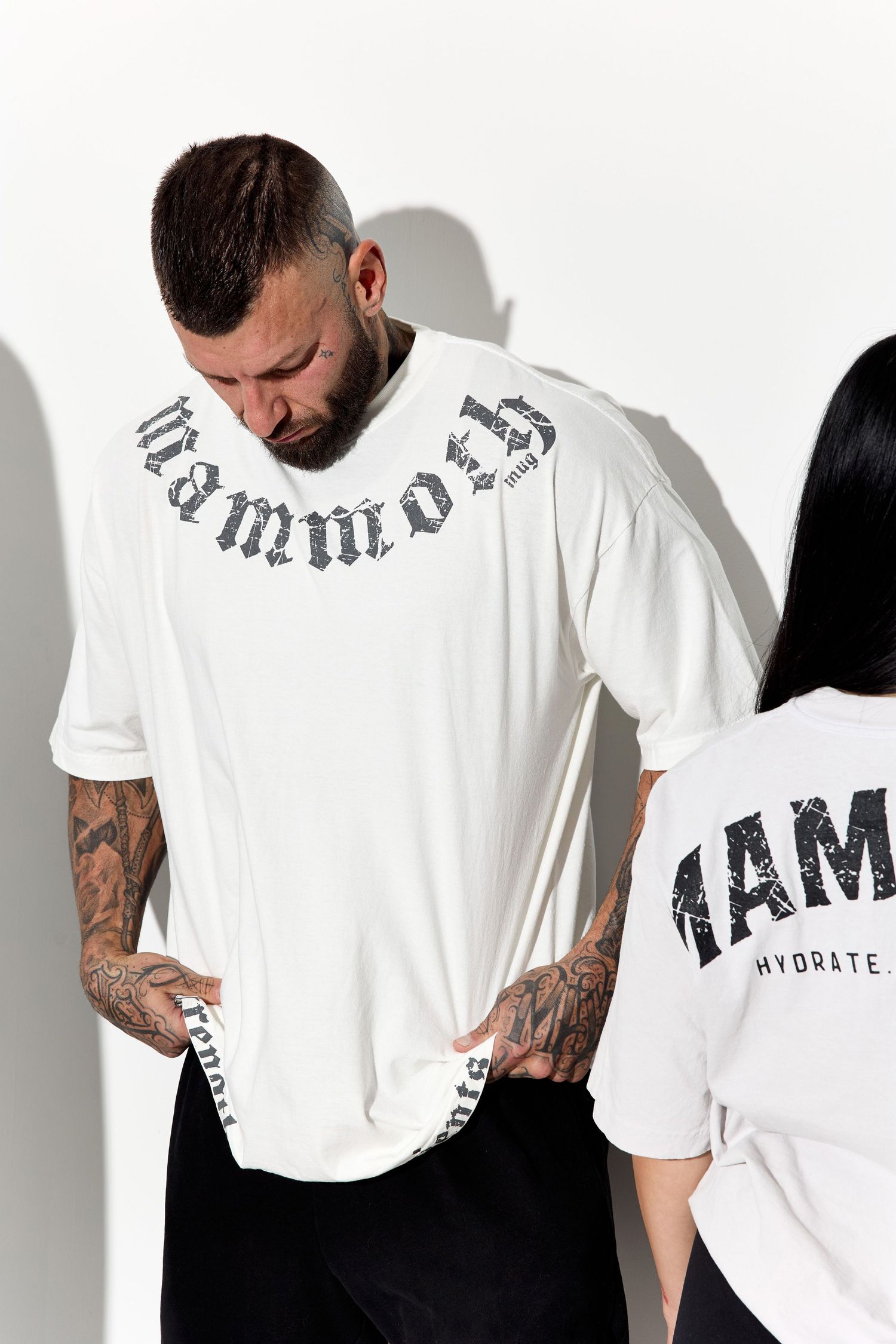 People wearing white branded t-shirts displaying various text designs.
