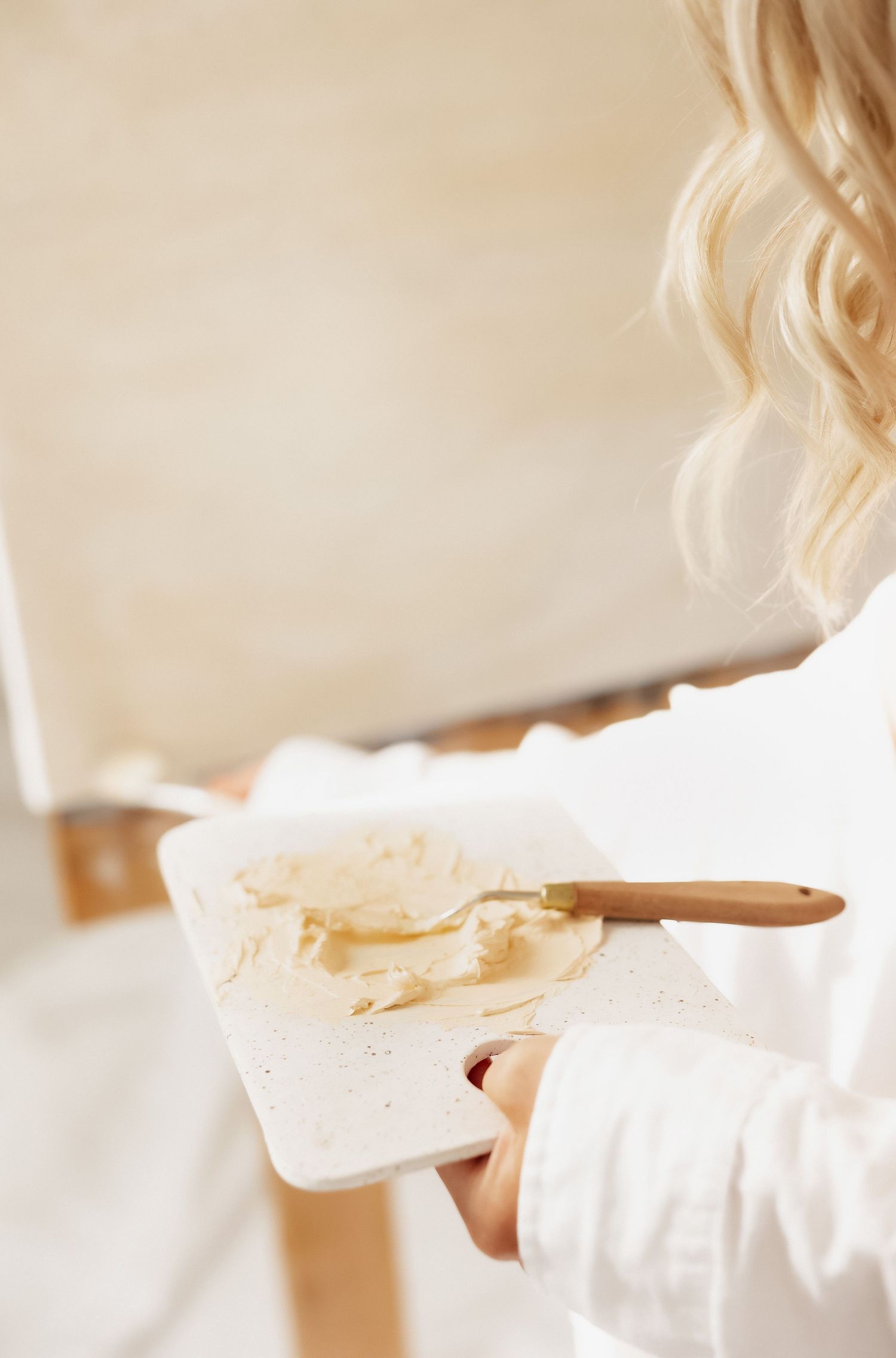 Close-up shot of paint palette with beige colors being mixed.