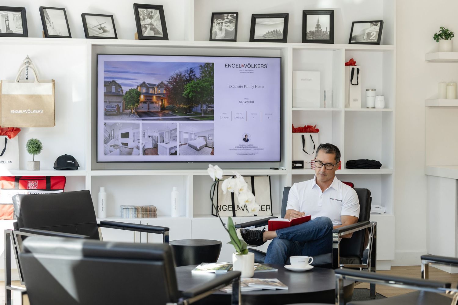 Modern white office space with framed certificates and digital displays.