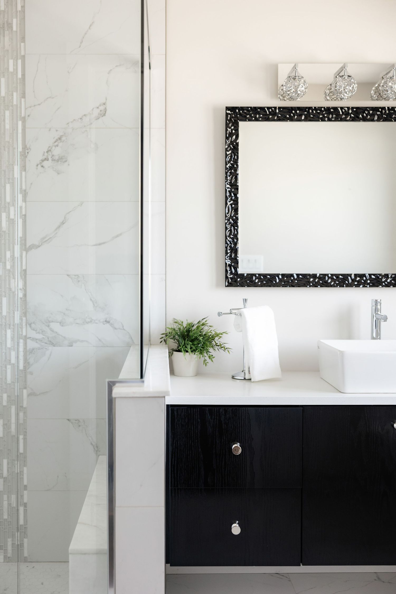 Luxurious bathroom interior with black vanity and marble walls featuring modern fixtures.