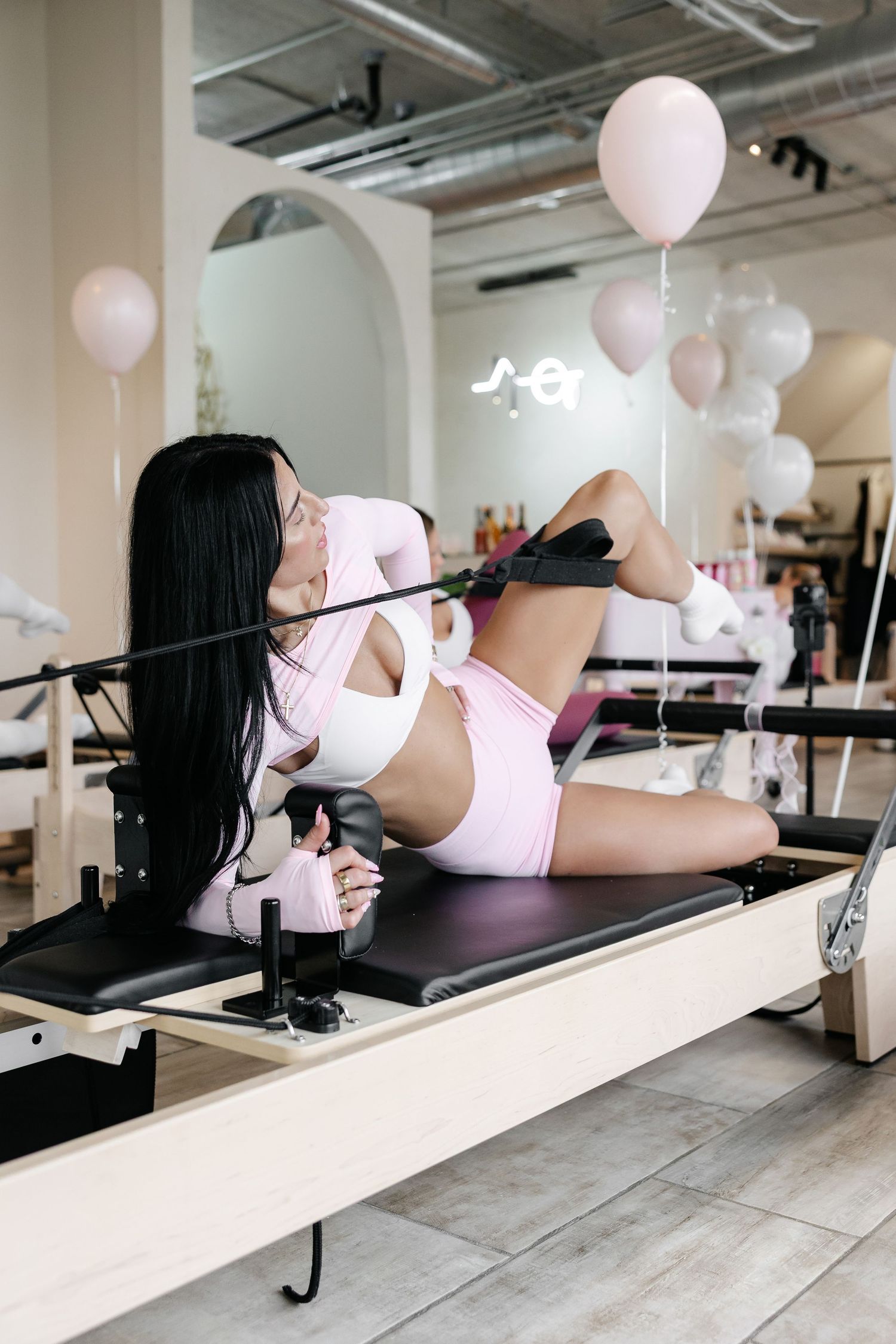 Clean modern pilates studio with white balloons and exercise equipment.