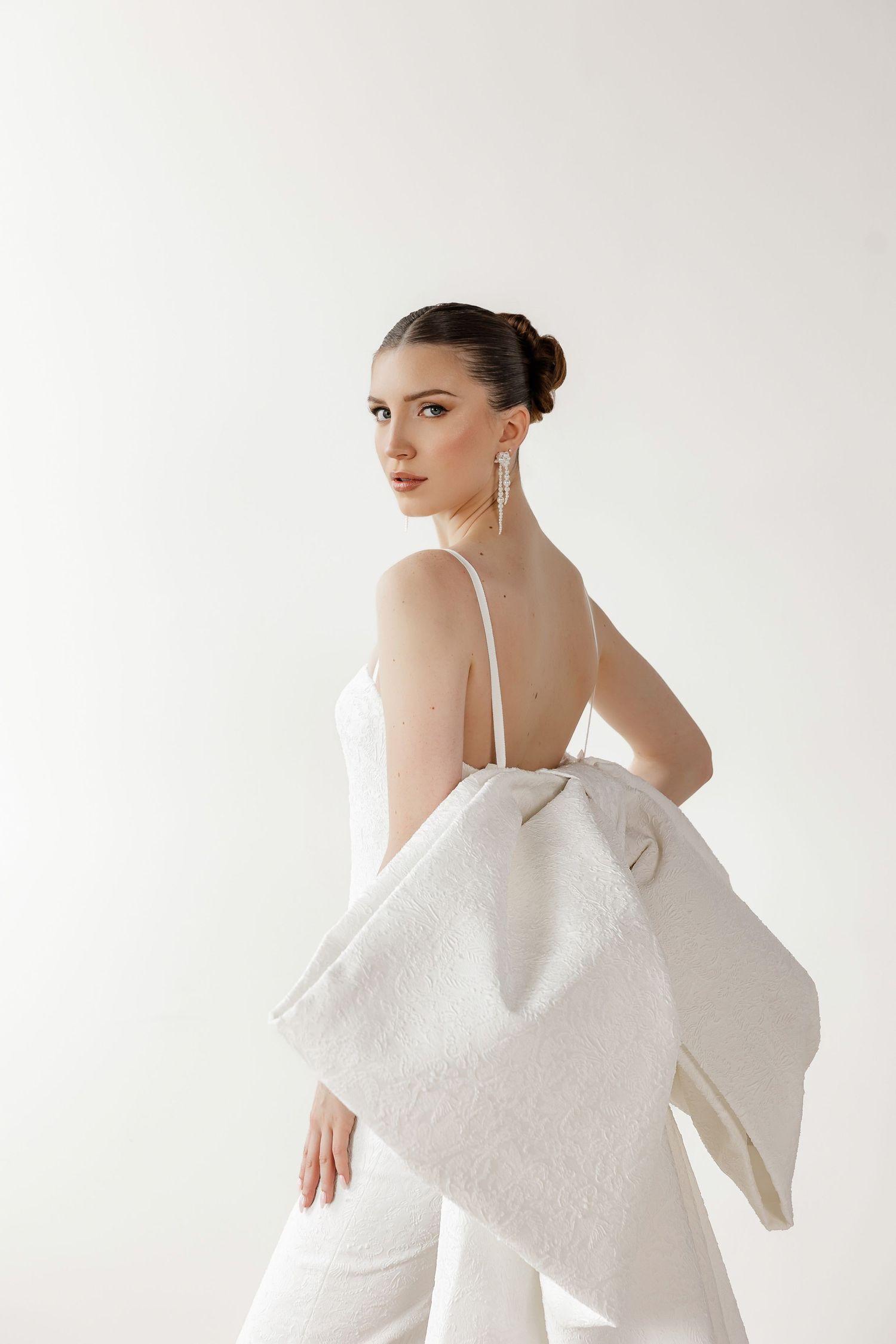 Minimalist bridal portrait showing off-shoulder design and elegant silhouette.