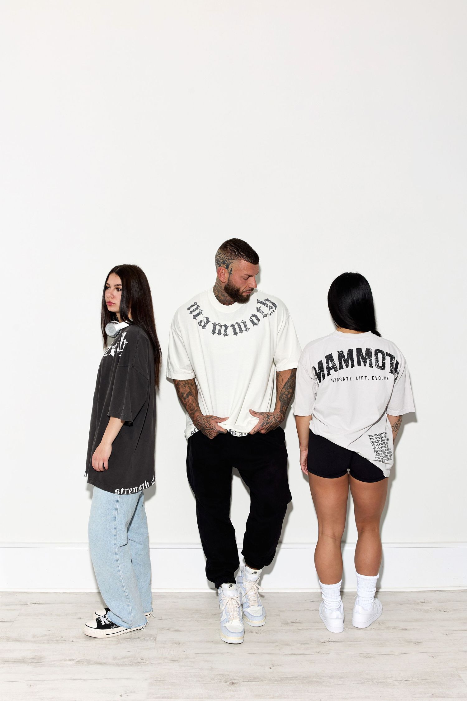 Group poses sitting against white wall wearing Mammoth branded apparel and sneakers.