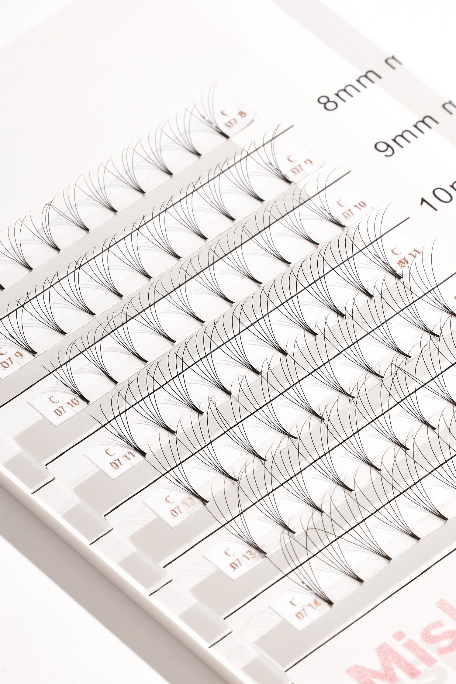 Professional eyelash extension strips labeled with different lengths from 8mm to 10mm.
