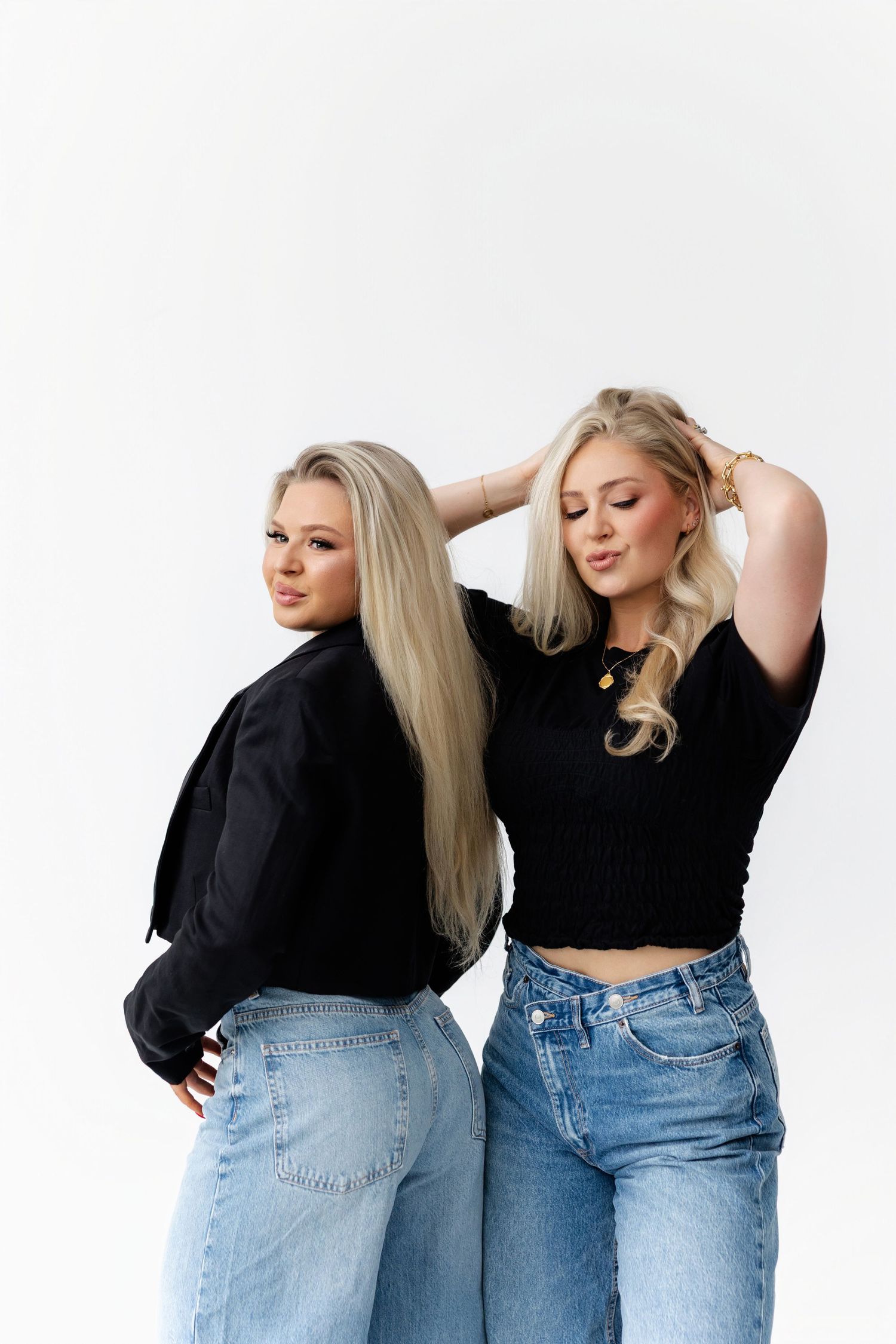 Candid fashion poses showing denim and black tops against white studio background.